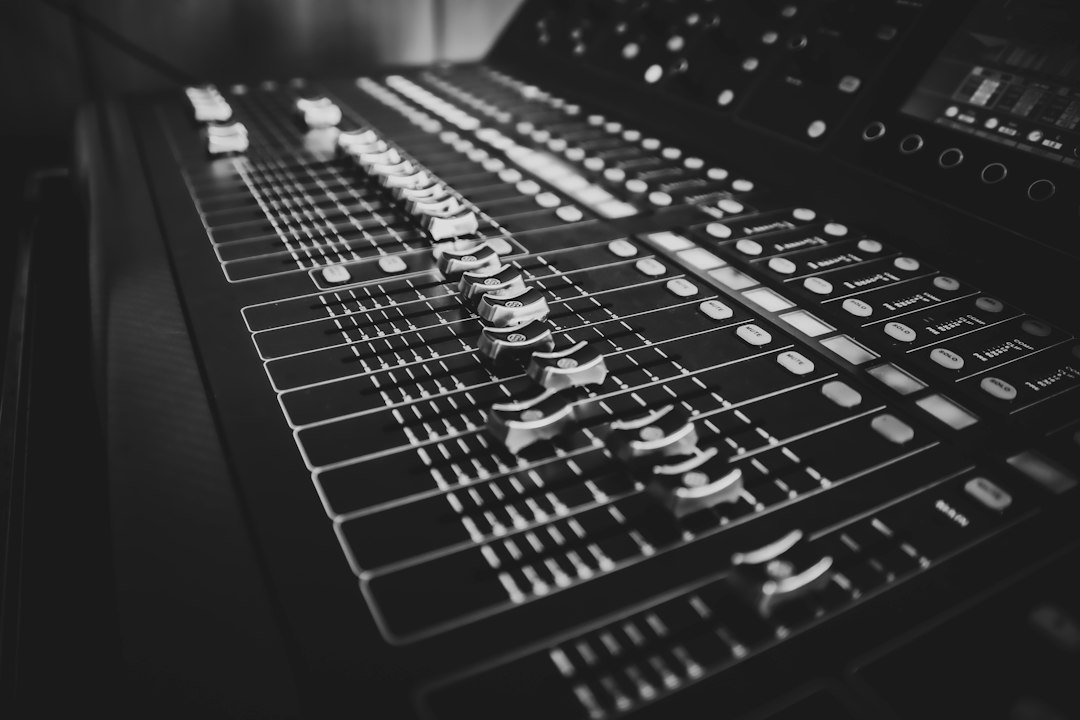 Faders and buttons stretch across a black and white audio mixing console