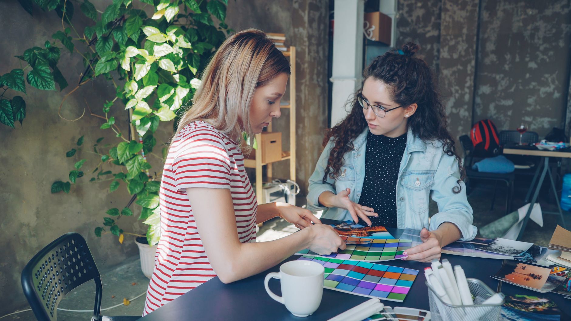 Two women discussing color palettes and images for branding and visual identity