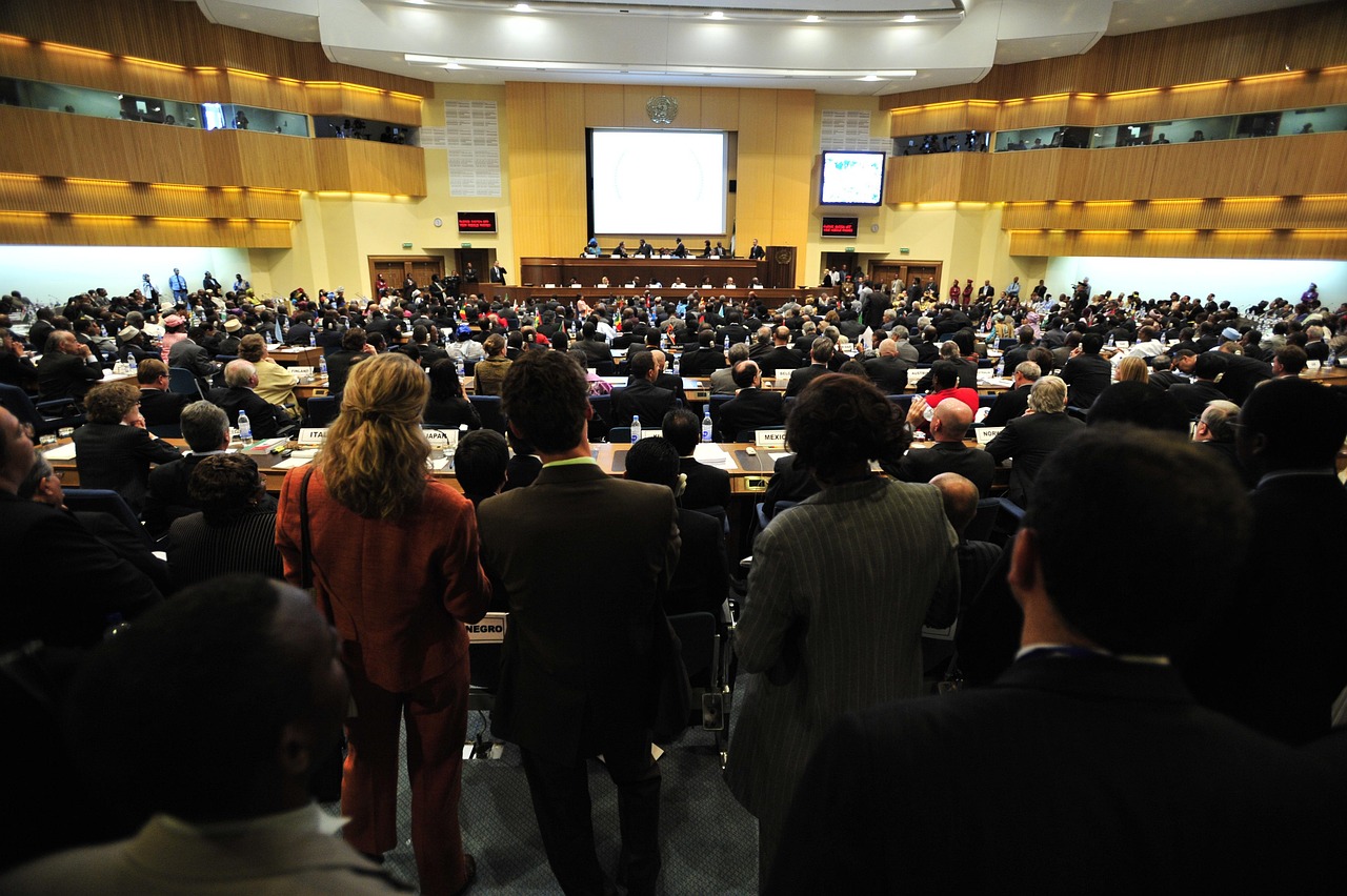 A diverse business audience fills a large auditorium for a corporate event