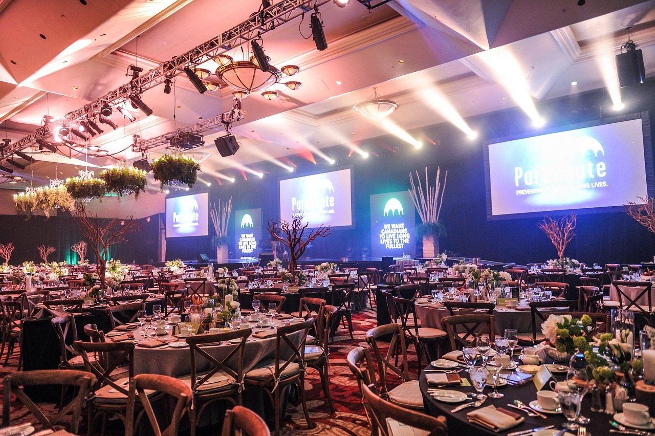 A large event hall with many round tables set for a corporate gala dinner
