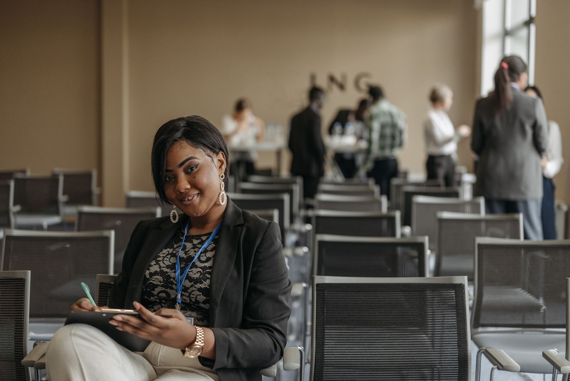 A smiling young woman takes notes at a corporate event