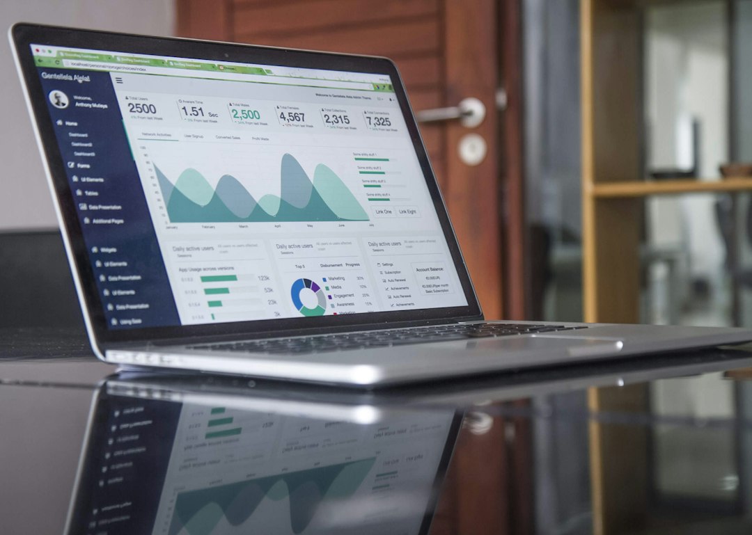 An open laptop displays an analytics dashboard on a reflective table