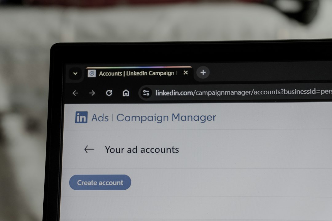 A laptop screen displays LinkedIn Campaign Manager for managing ad accounts