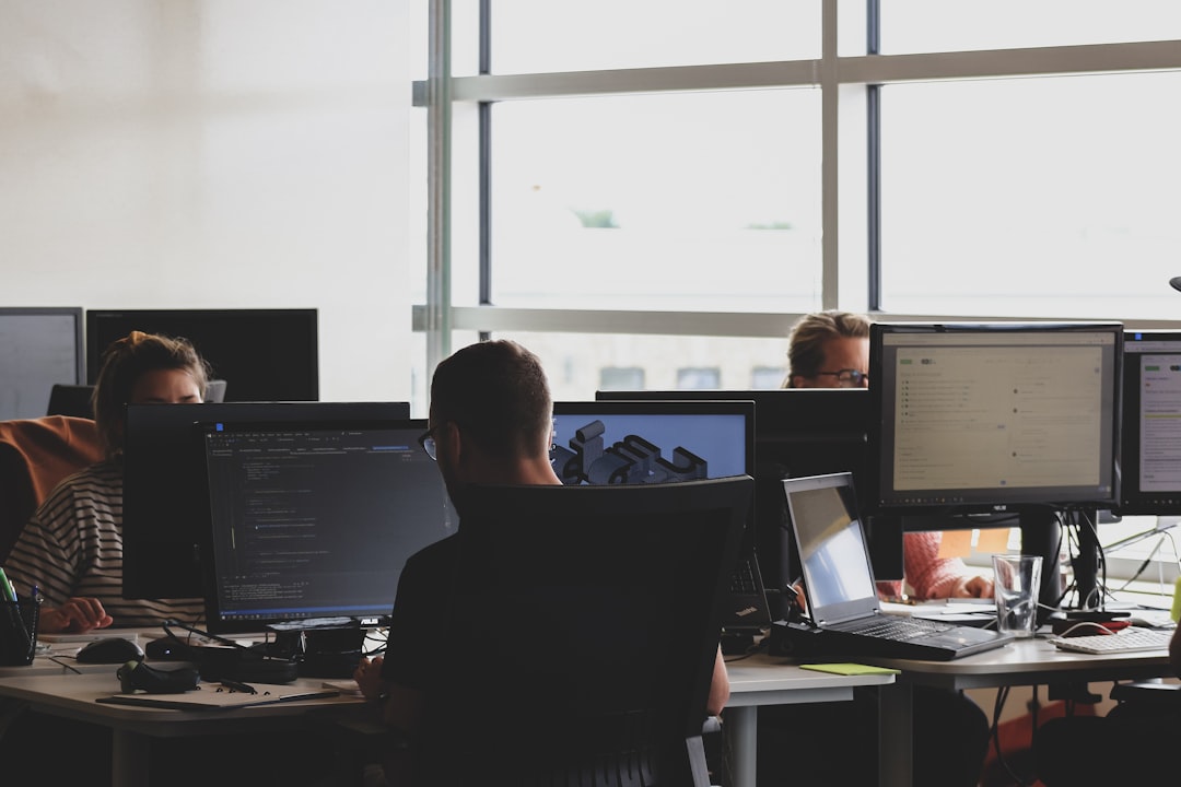 Developers working intently on computers in a bright, modern office environment