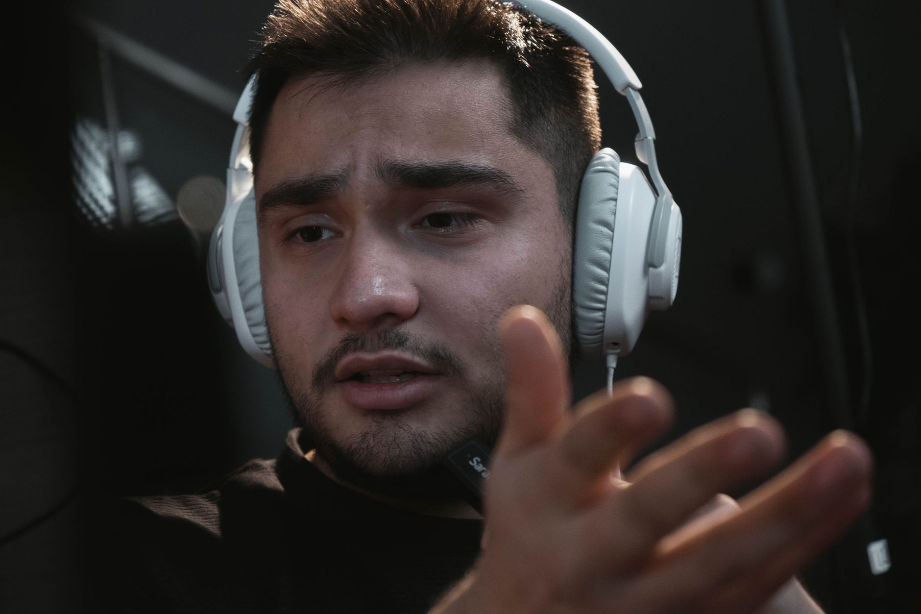 Man with white headphones and microphone speaks, likely recording a host-read ad