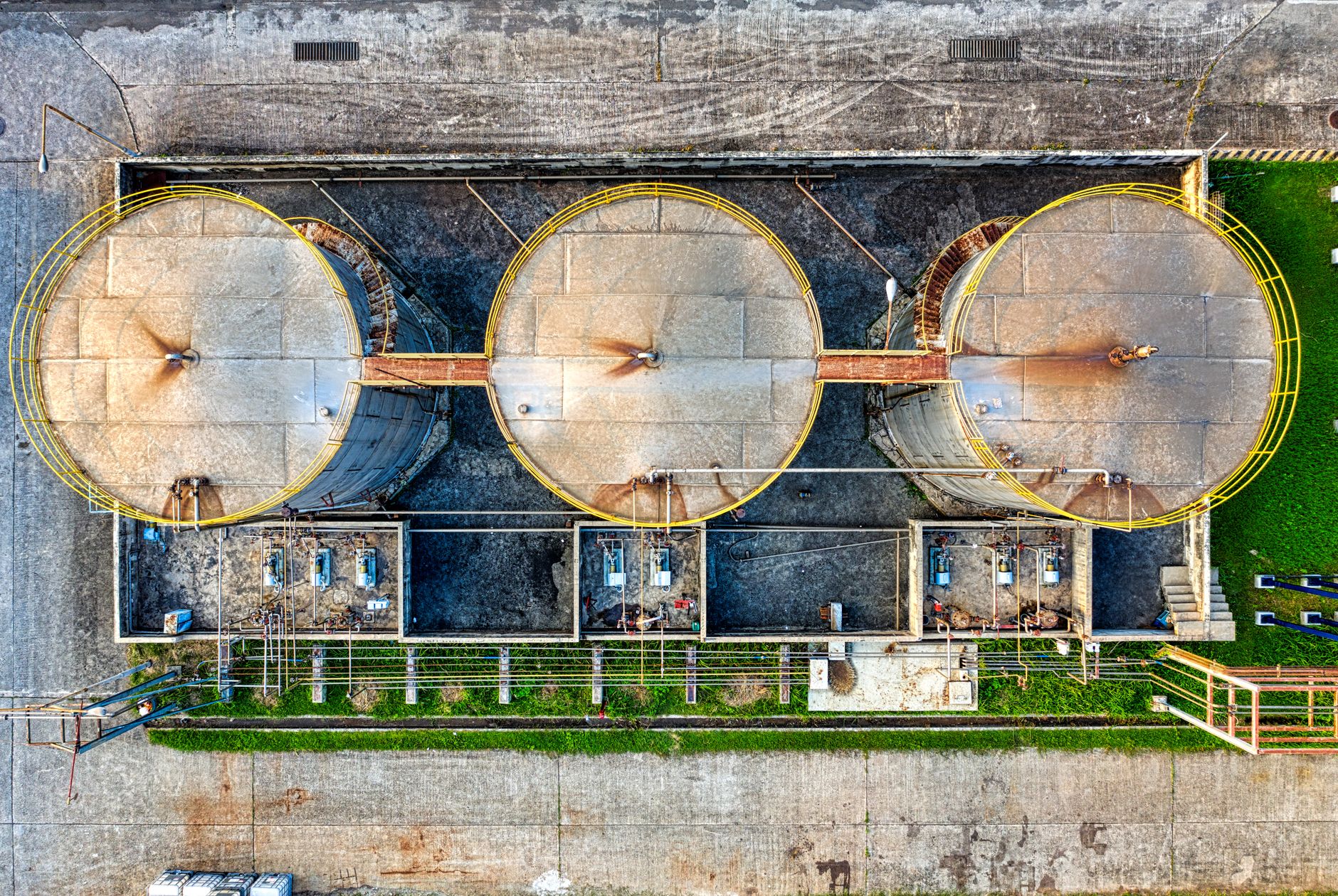 Aerial view of three large industrial storage tanks at an oil facility