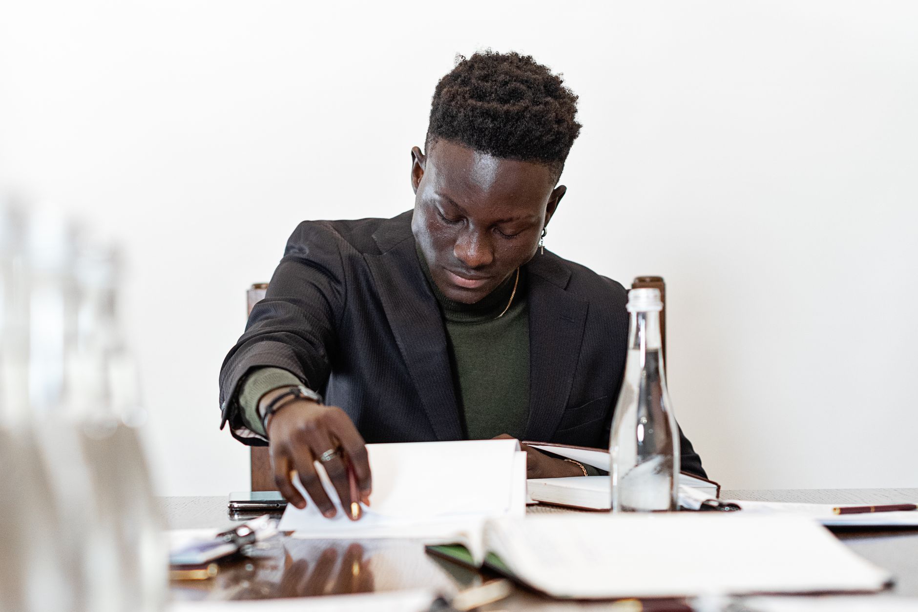 A professional man reviewing documents and notes at a boardroom table