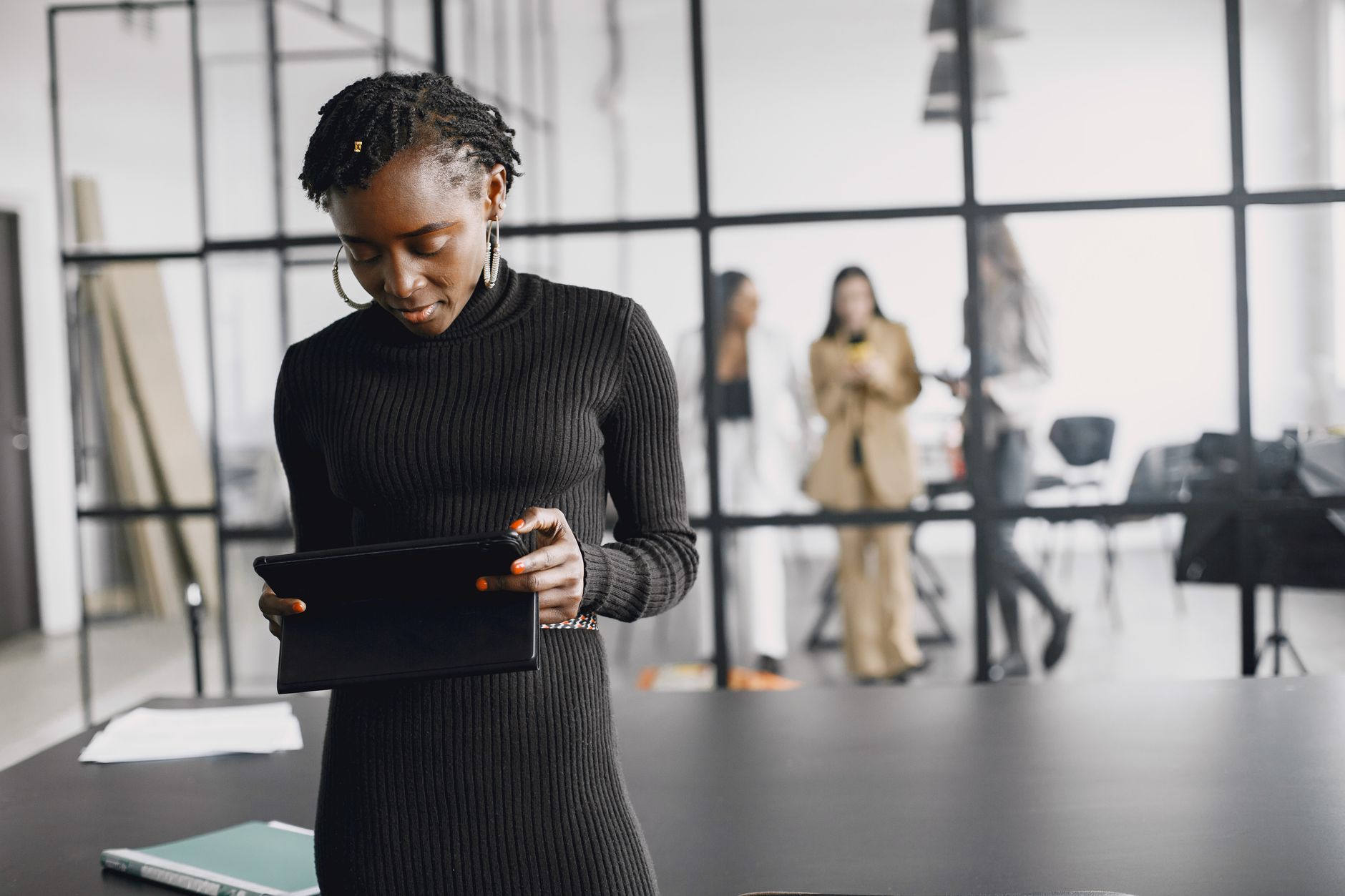 Woman looking at a tablet to manage event RSVPs in an office