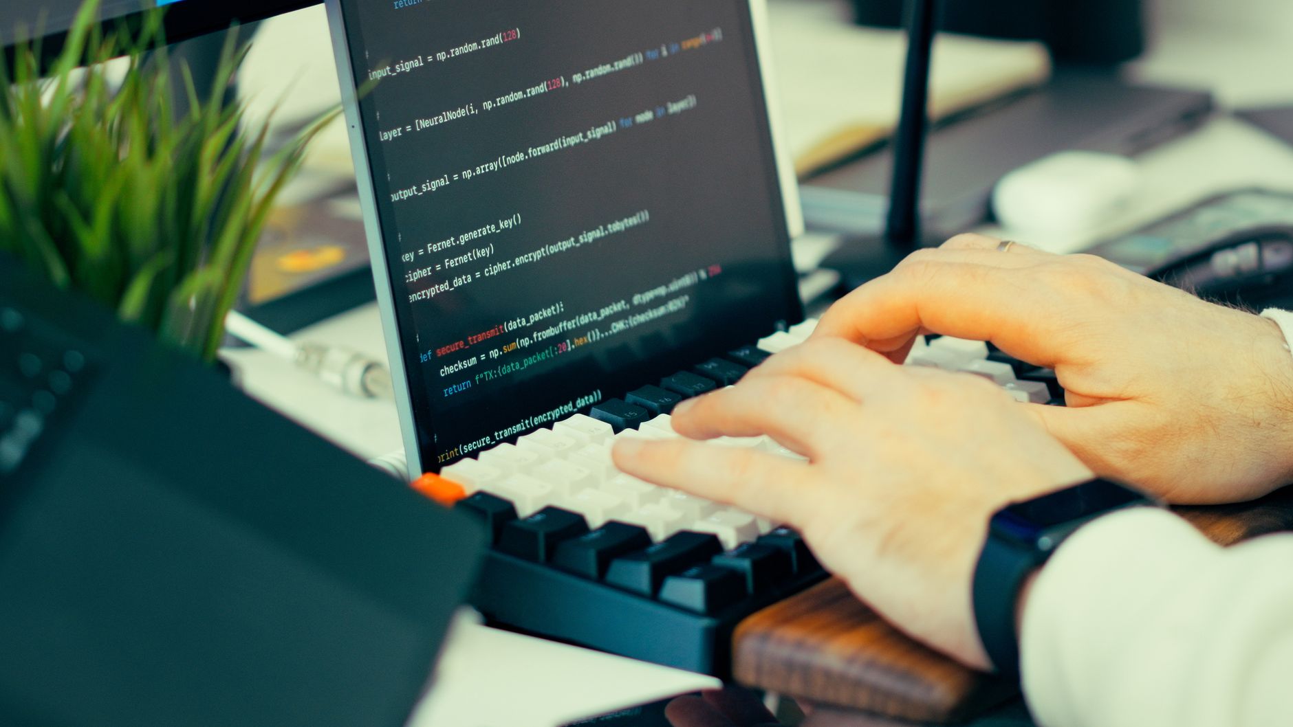 A man wearing glasses views lines of code on a computer screen