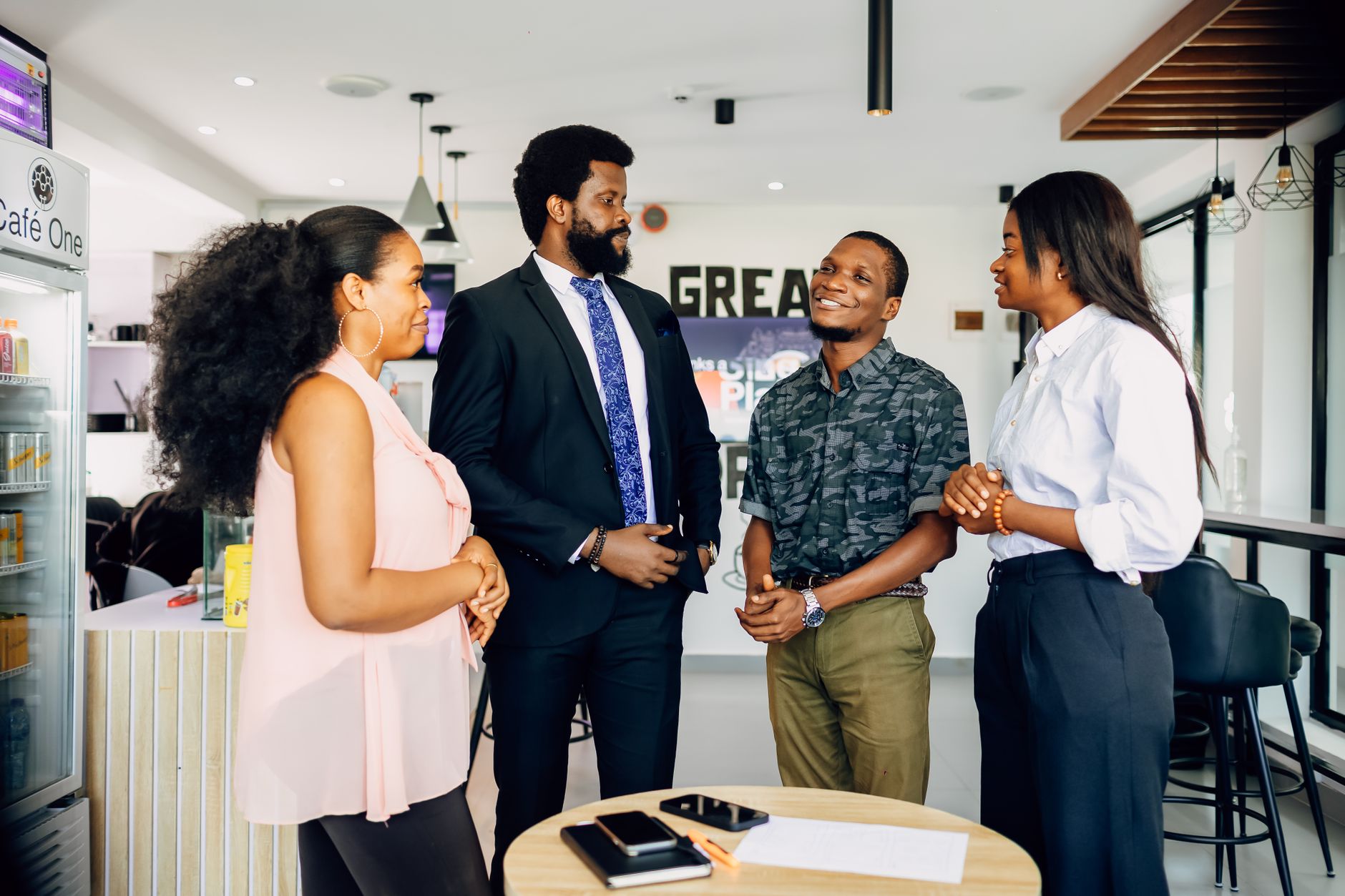 Four Nigerian professionals in a business discussion, possibly negotiating an agreement