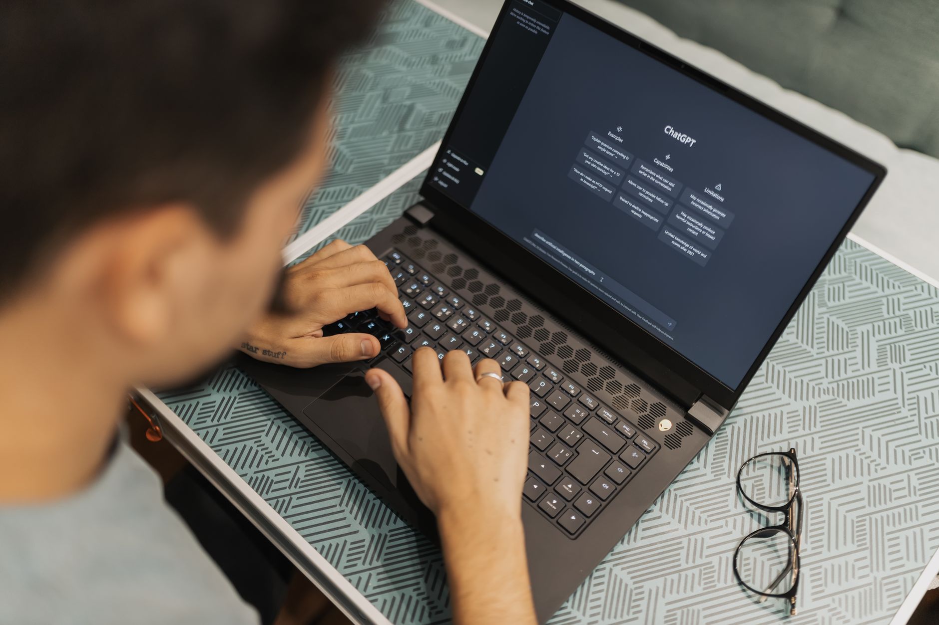 Person typing on a laptop with the ChatGPT interface displayed on the screen