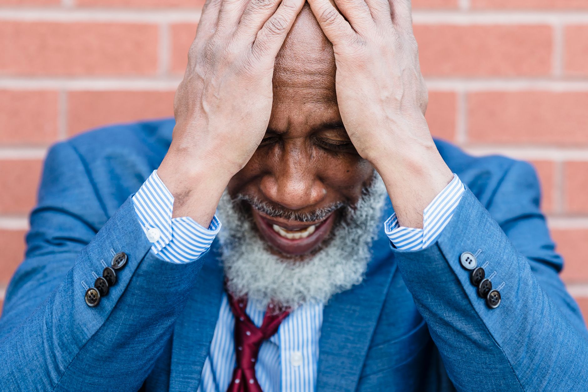 A distressed man in a suit covers his face, likely facing legal property issues