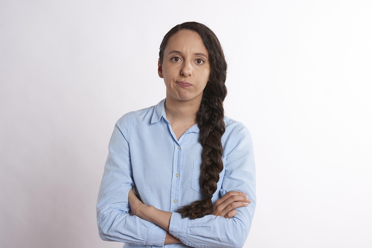 Woman with braided hair and crossed arms looking concerned about litigation options