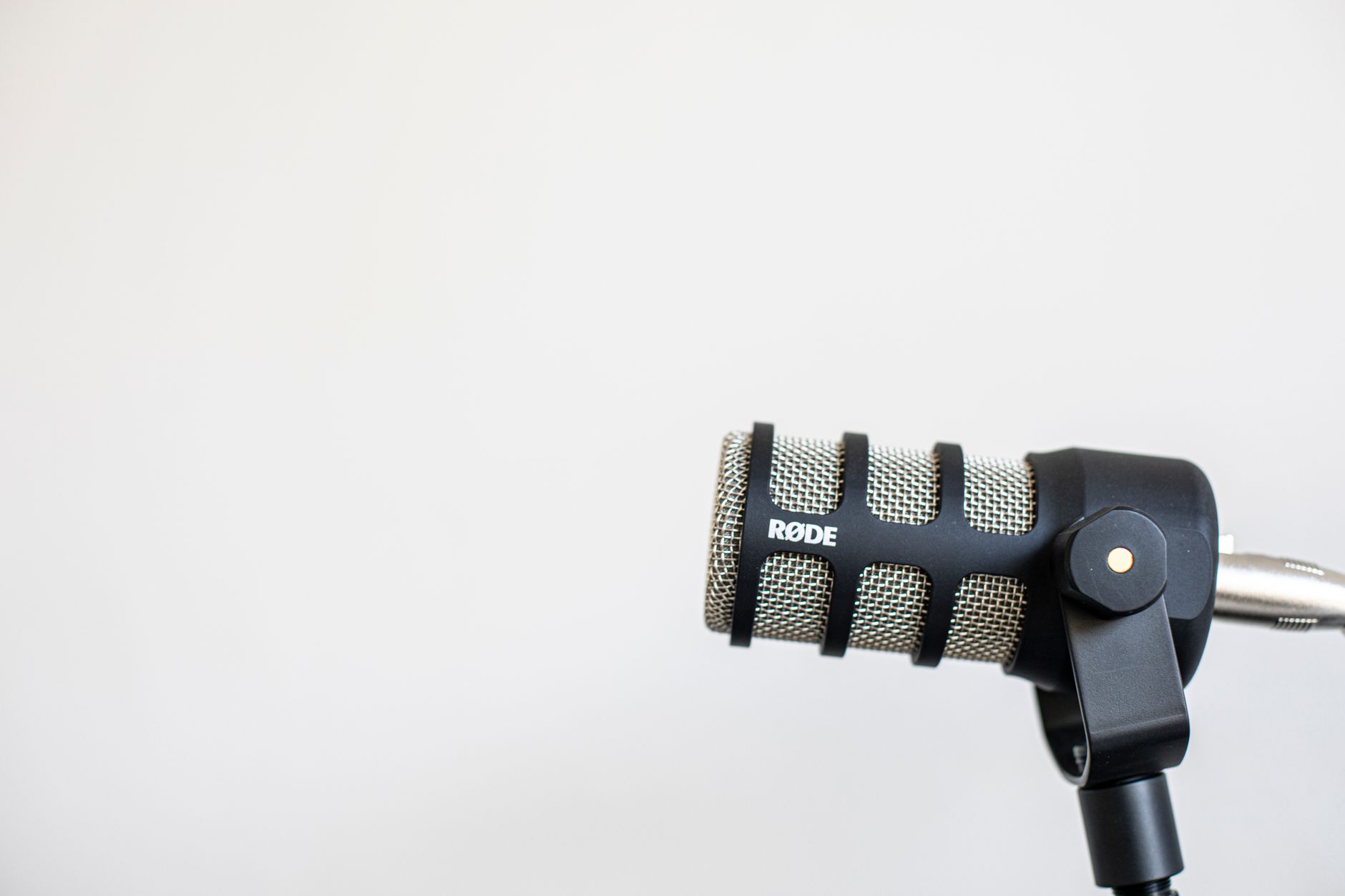 A black Røde microphone on a stand, suitable for podcast recording