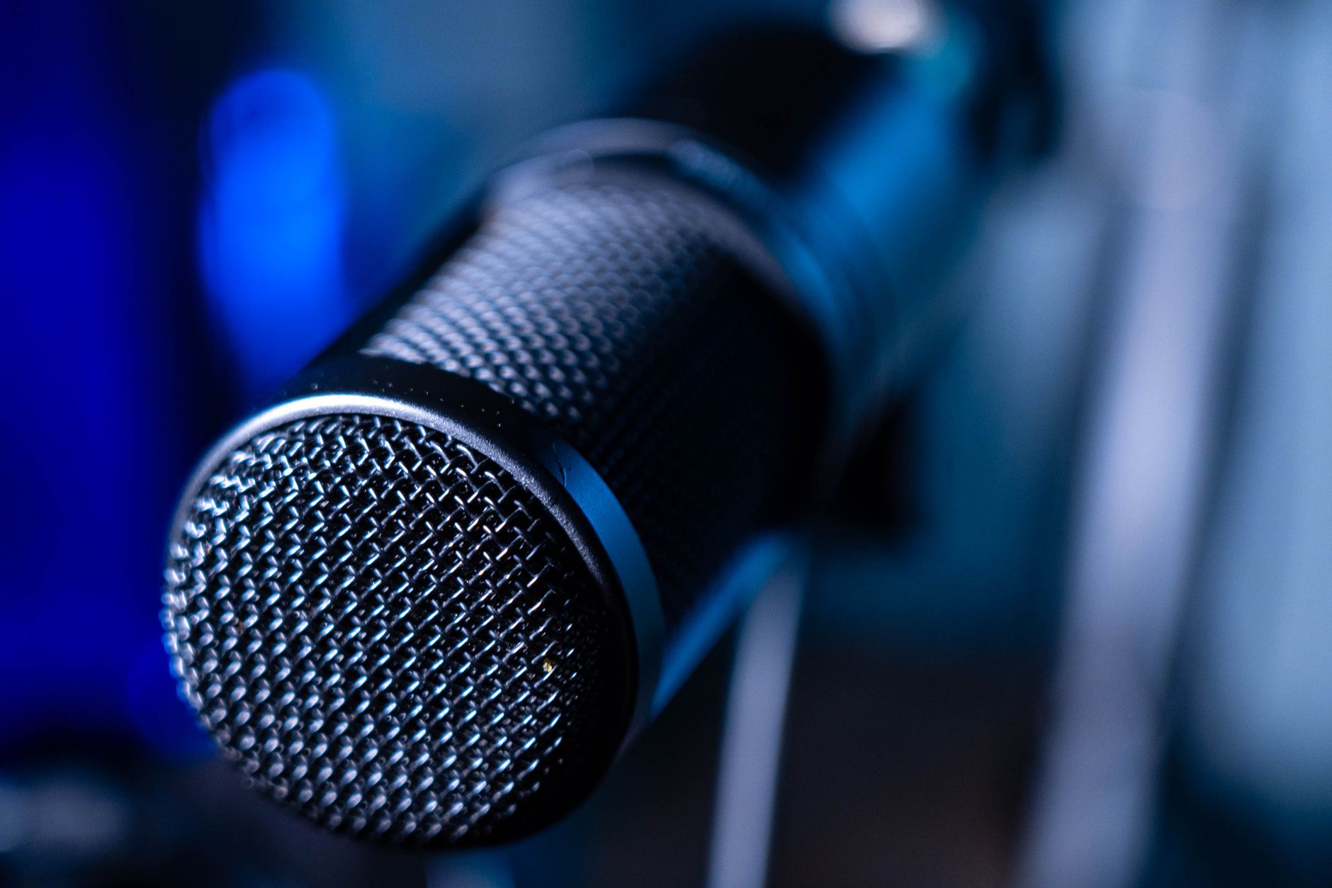Close-up of a black podcast microphone with a metal mesh grille