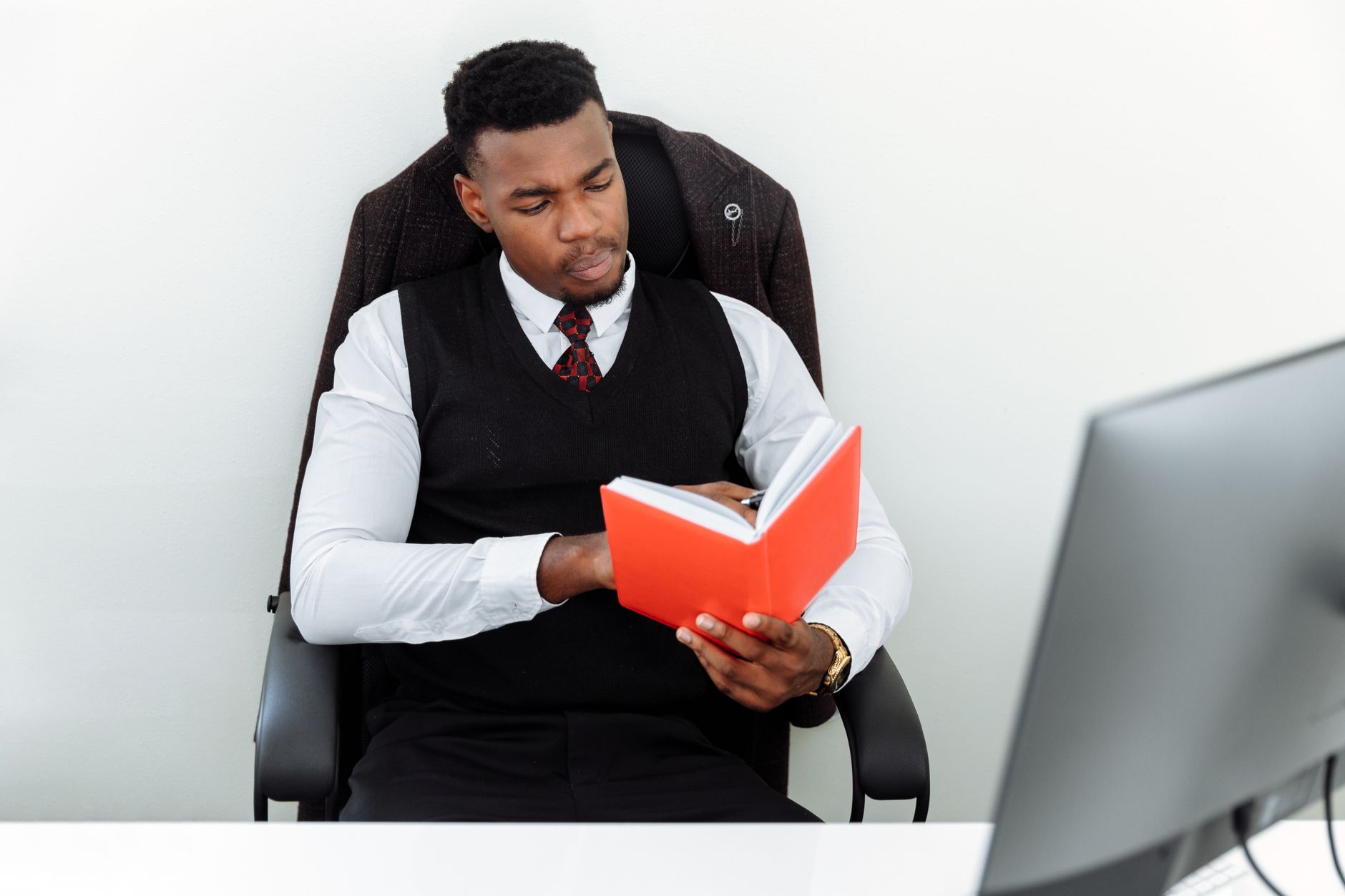 Professional man in an office chair reading a red book, understanding IP landscape