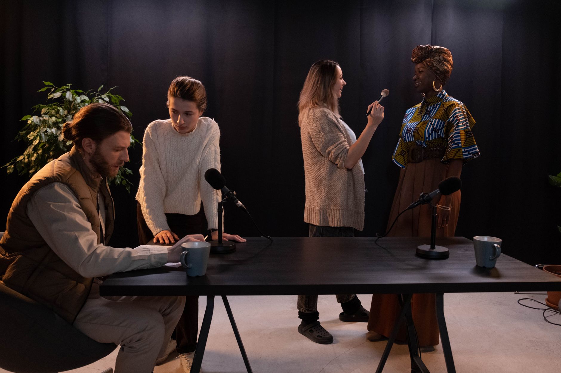 People preparing and recording a podcast in a dimly lit studio setting