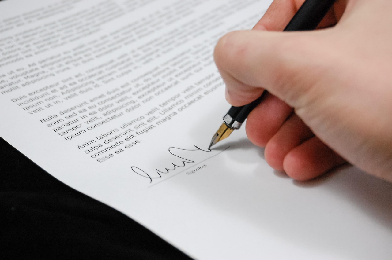 Hand signing a legal document with a pen, preparing a notice to quit