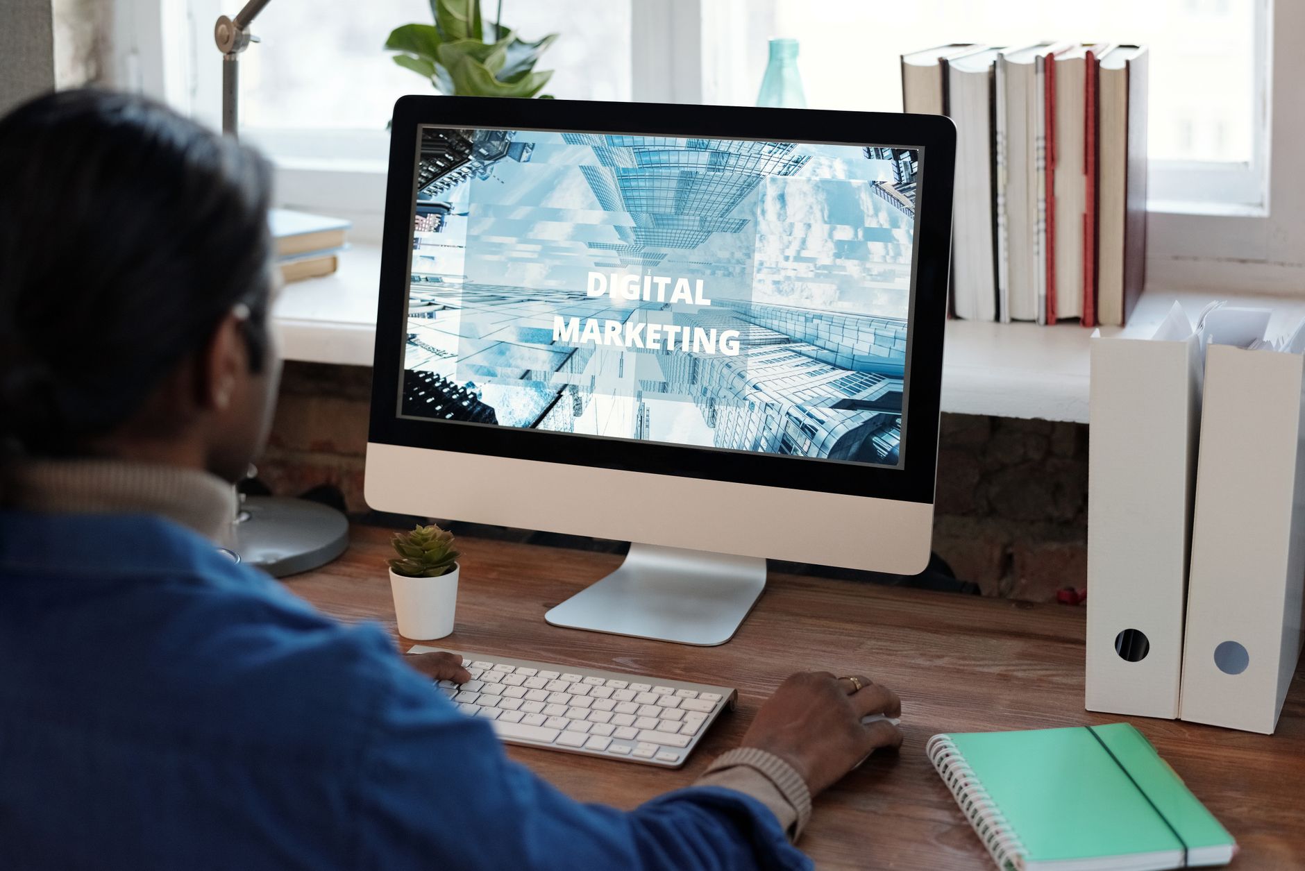 Person views a computer screen displaying "Digital Marketing" text and city buildings