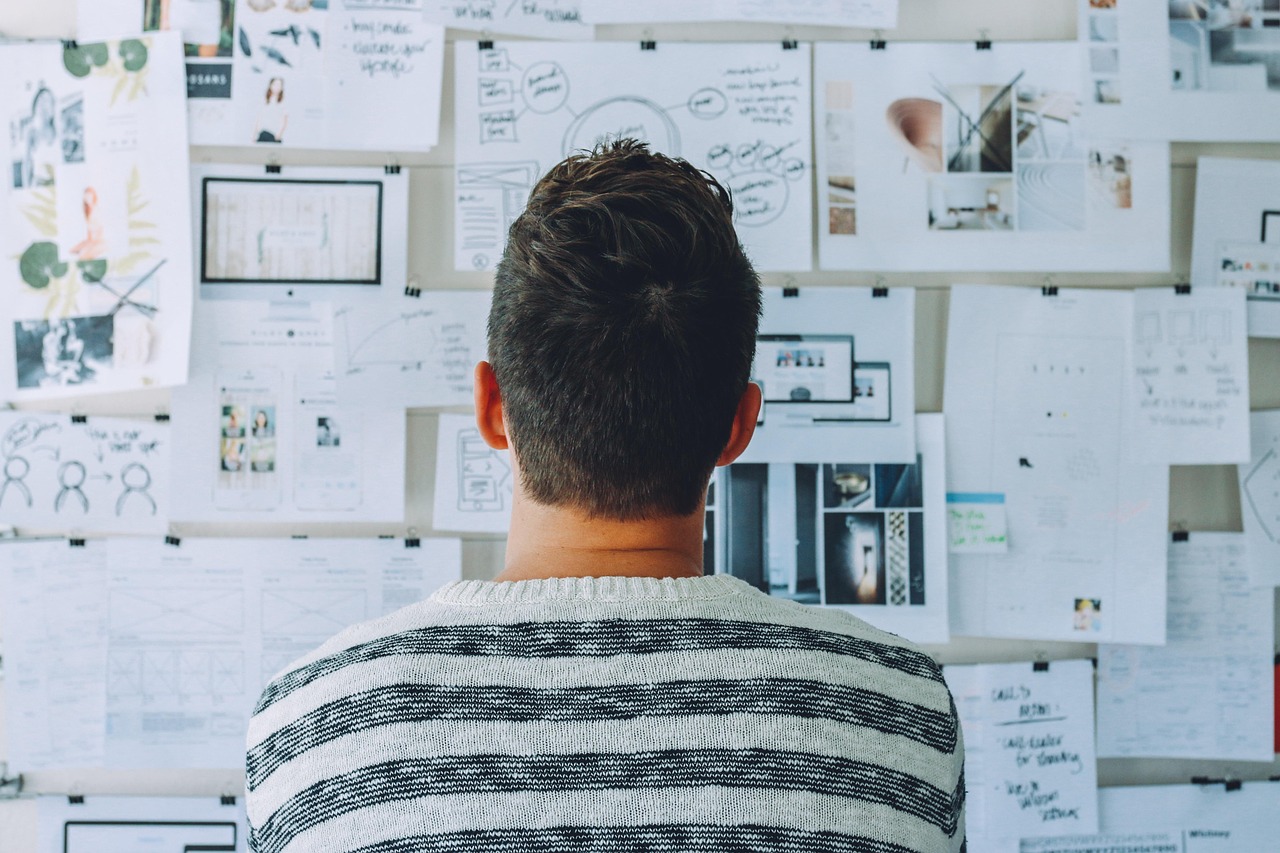 Person from behind looking at a wall covered with keyword research ideas and plans