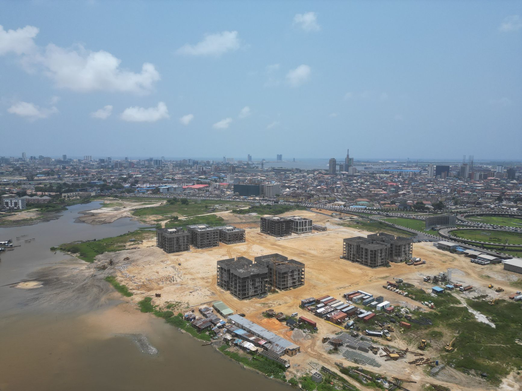Aerial view of Lagos showing buildings under construction beside a river and city skyline