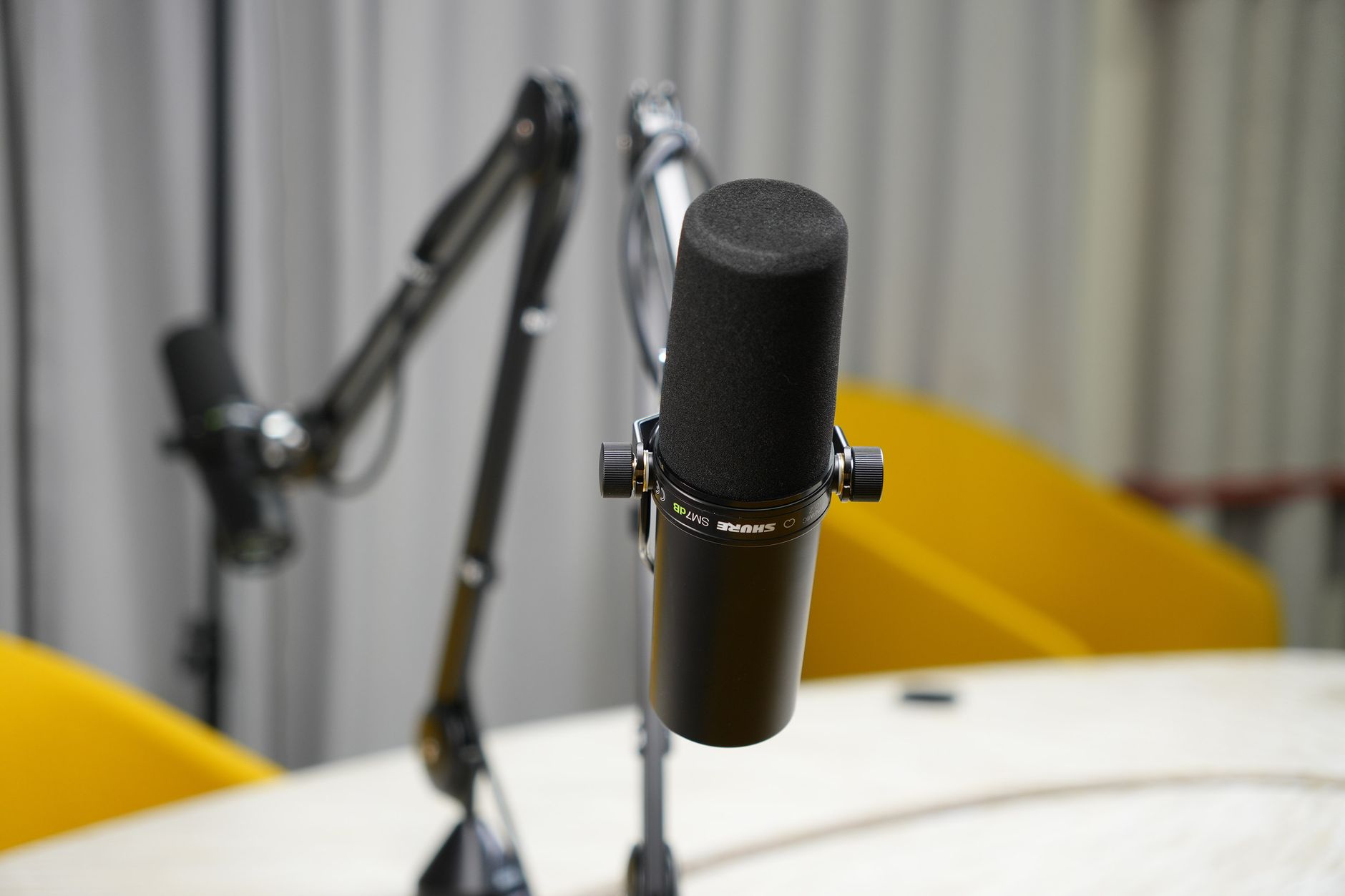A professional Shure SM7B podcast microphone on a boom arm in a studio