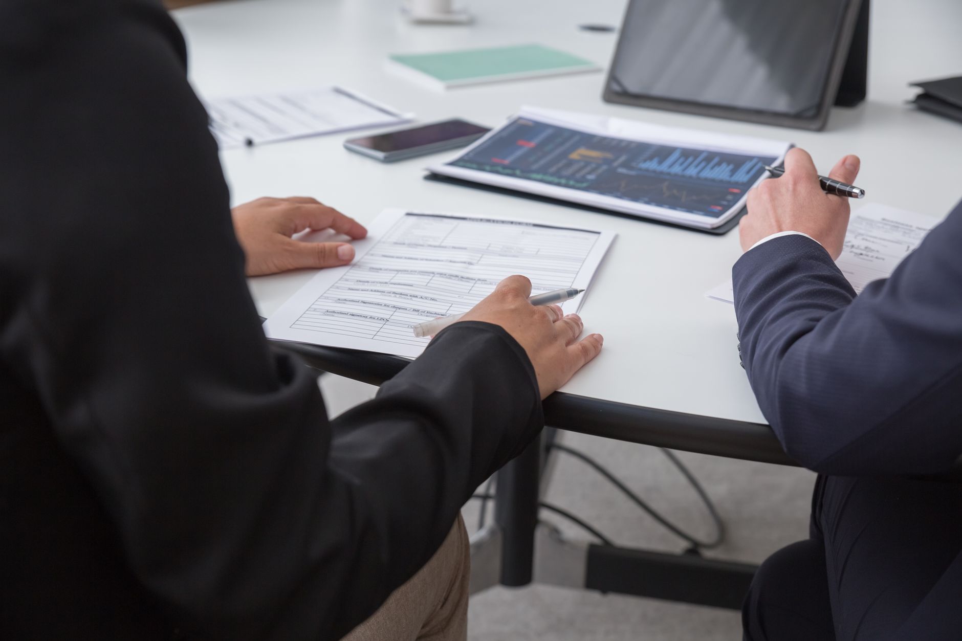 Two business professionals review documents and data during a conversion rate optimization meeting
