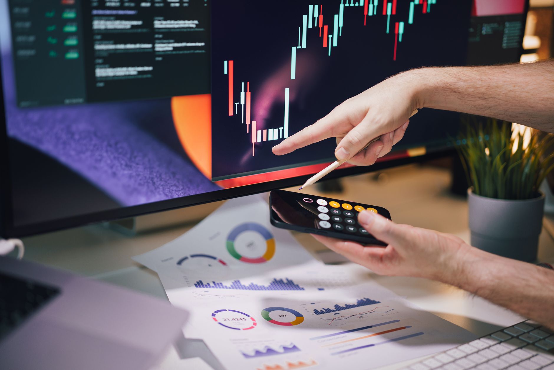 Hand pointing at a monitor displaying data charts, analyzing digital analytics and traffic metrics
