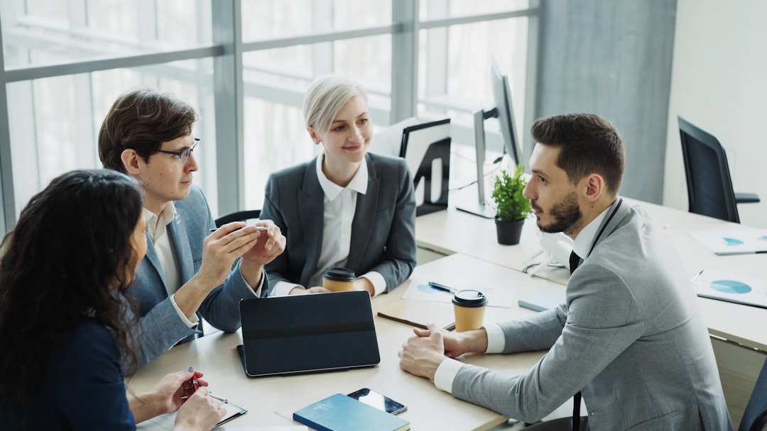 Four business people discussing ecommerce website development around a modern table