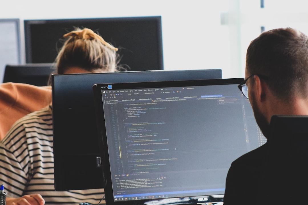 Developers coding on computer screens, demonstrating technical proficiency in website development