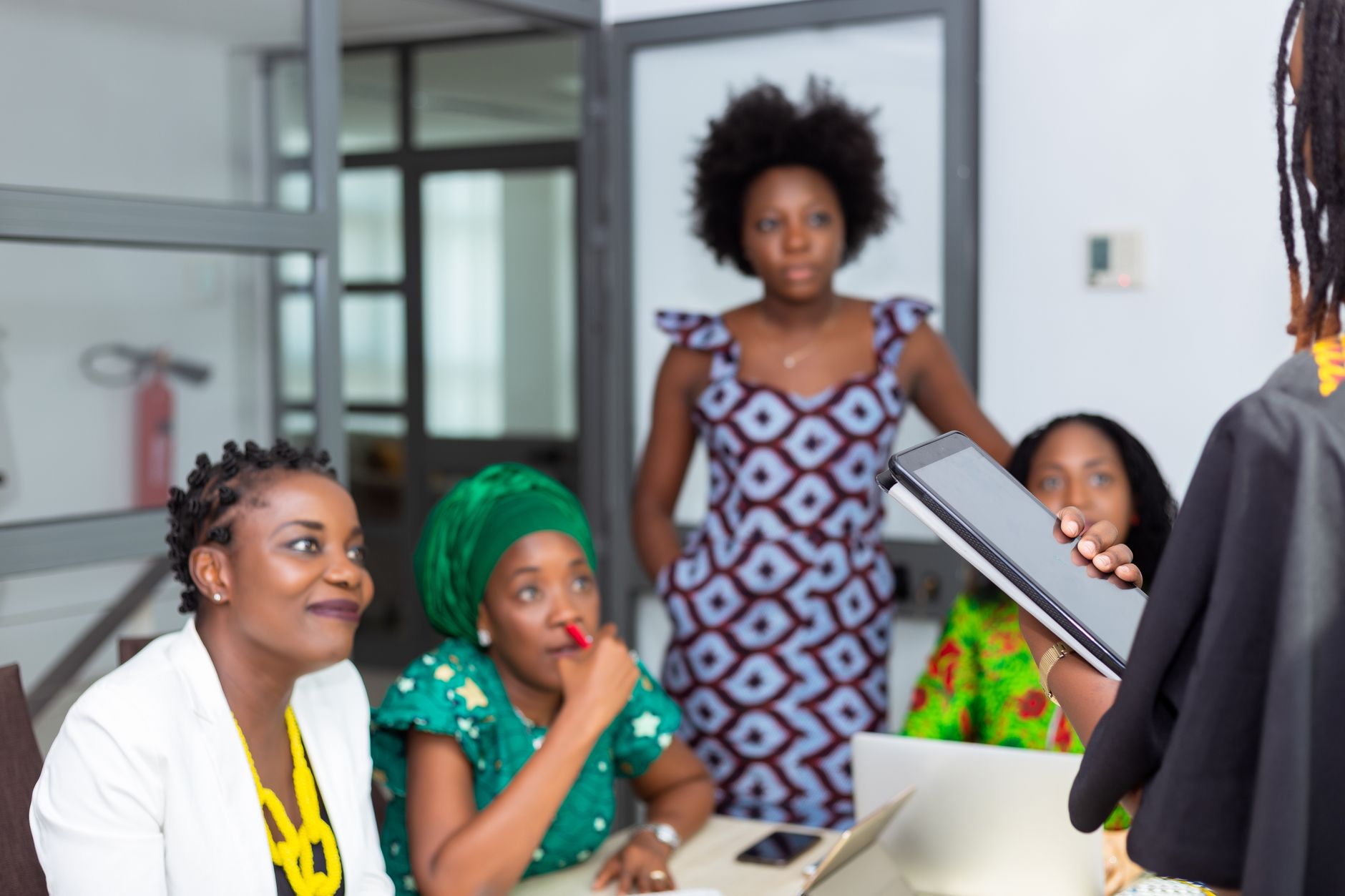 African businesswomen collaborating in a professional meeting setting with a tablet