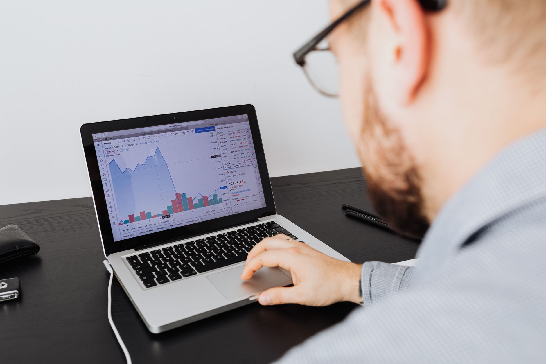 Person views financial charts on a laptop, analyzing data for podcast ad pricing models
