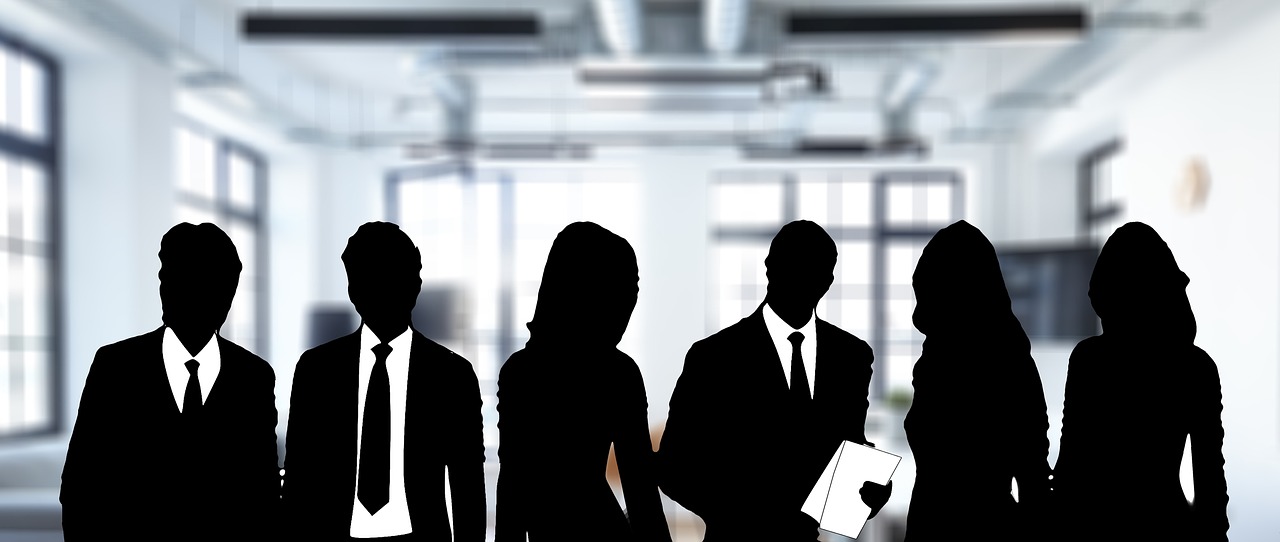 Silhouettes of six business people in an office representing a team or sponsors