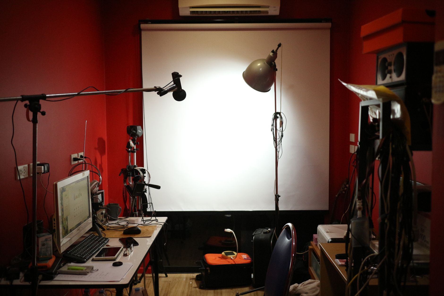 A red-walled studio with production equipment for podcast recording and optimization
