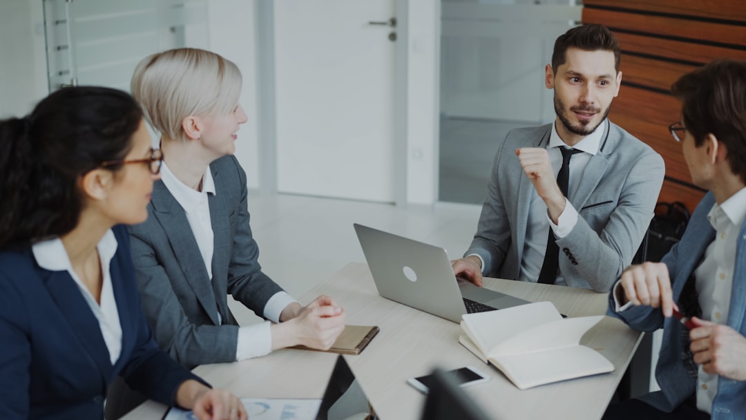 Professionals in suits discuss hiring a custom website development agency at a table