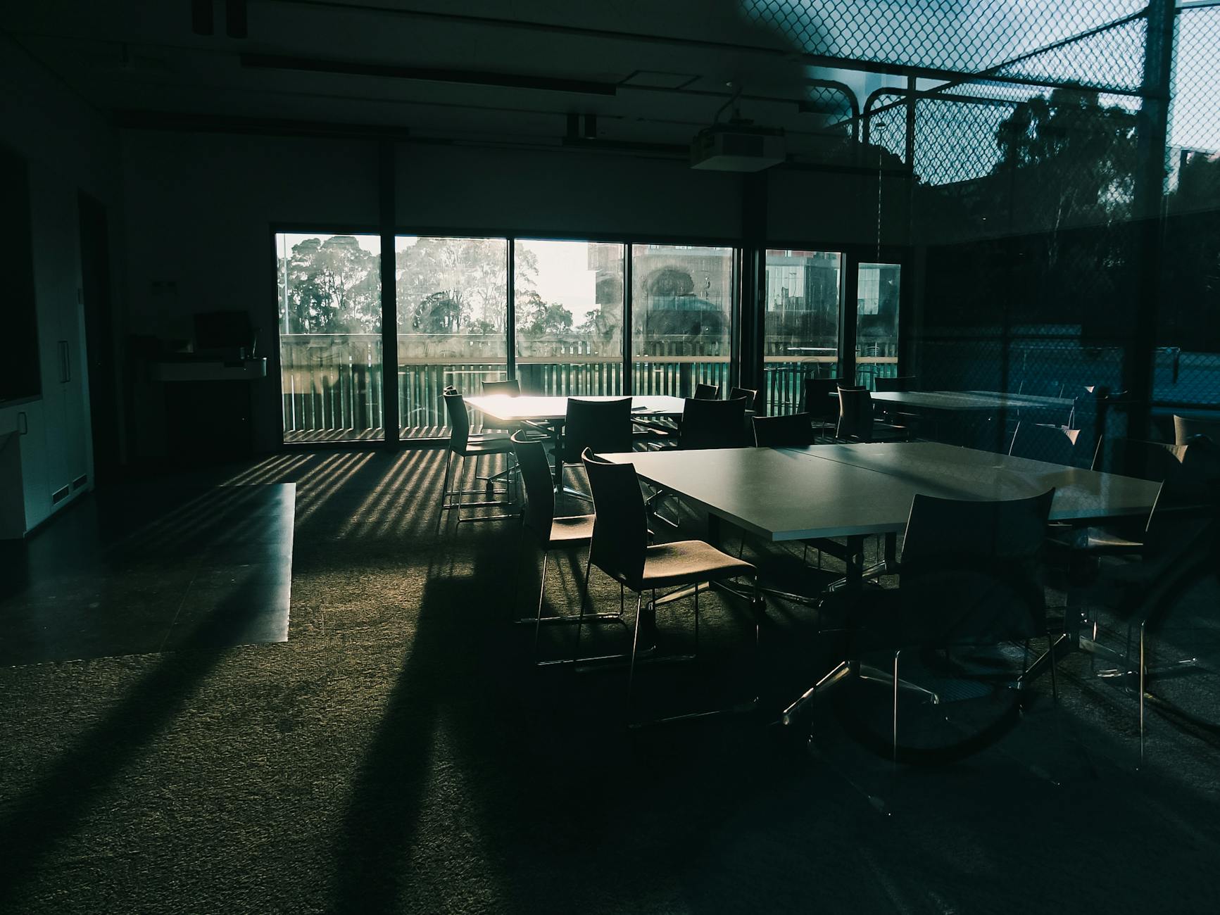 Sunlight streams into a dark, empty corporate event or meeting room