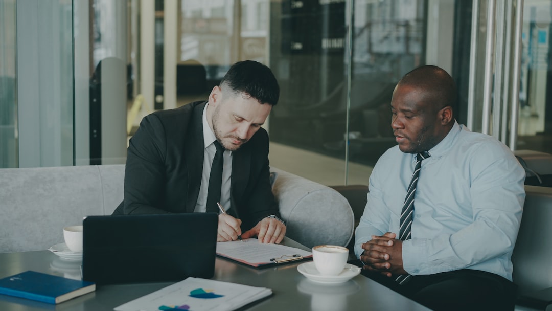 Two businessmen reviewing documents and discussing options in an office setting