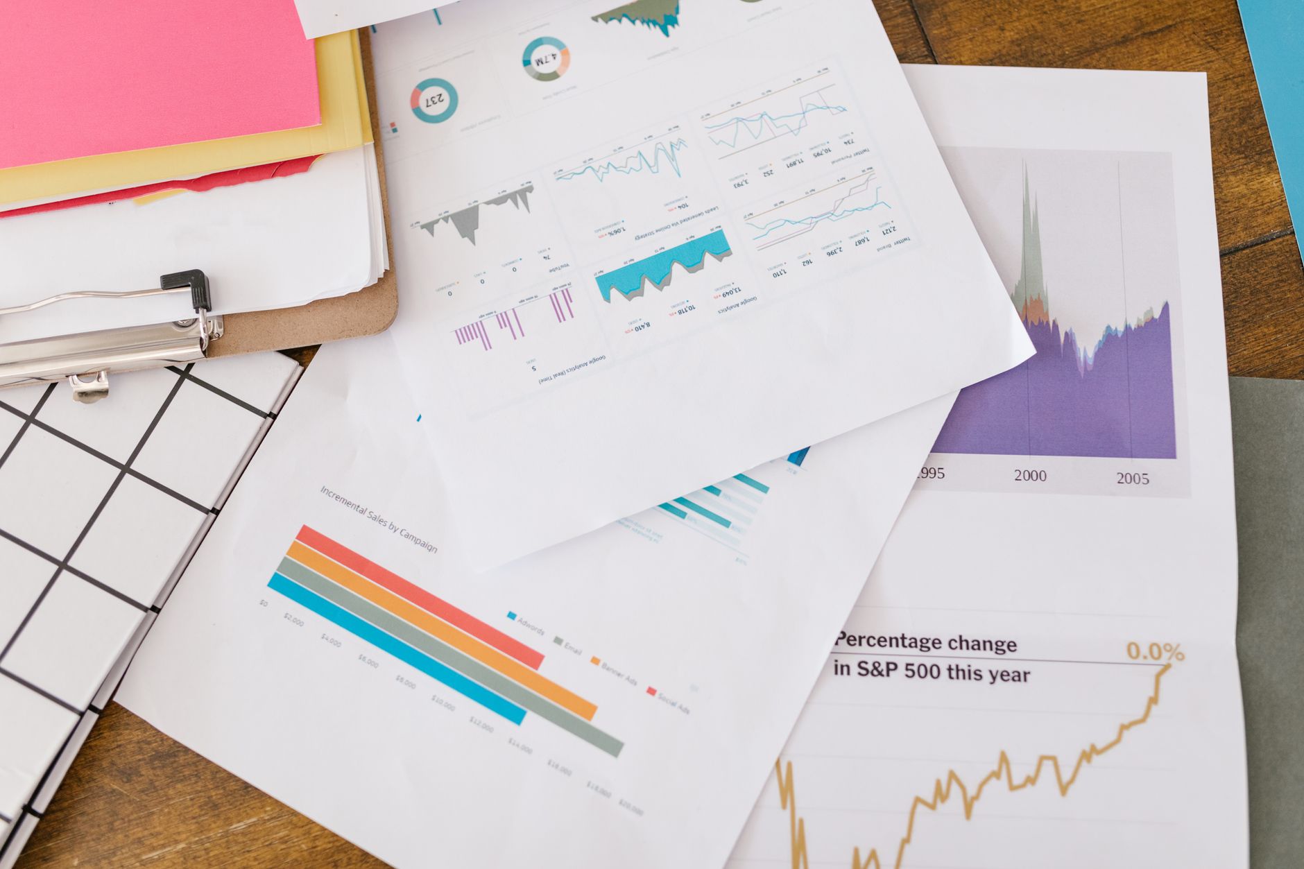 Overhead view of scattered papers displaying various data charts and graphs