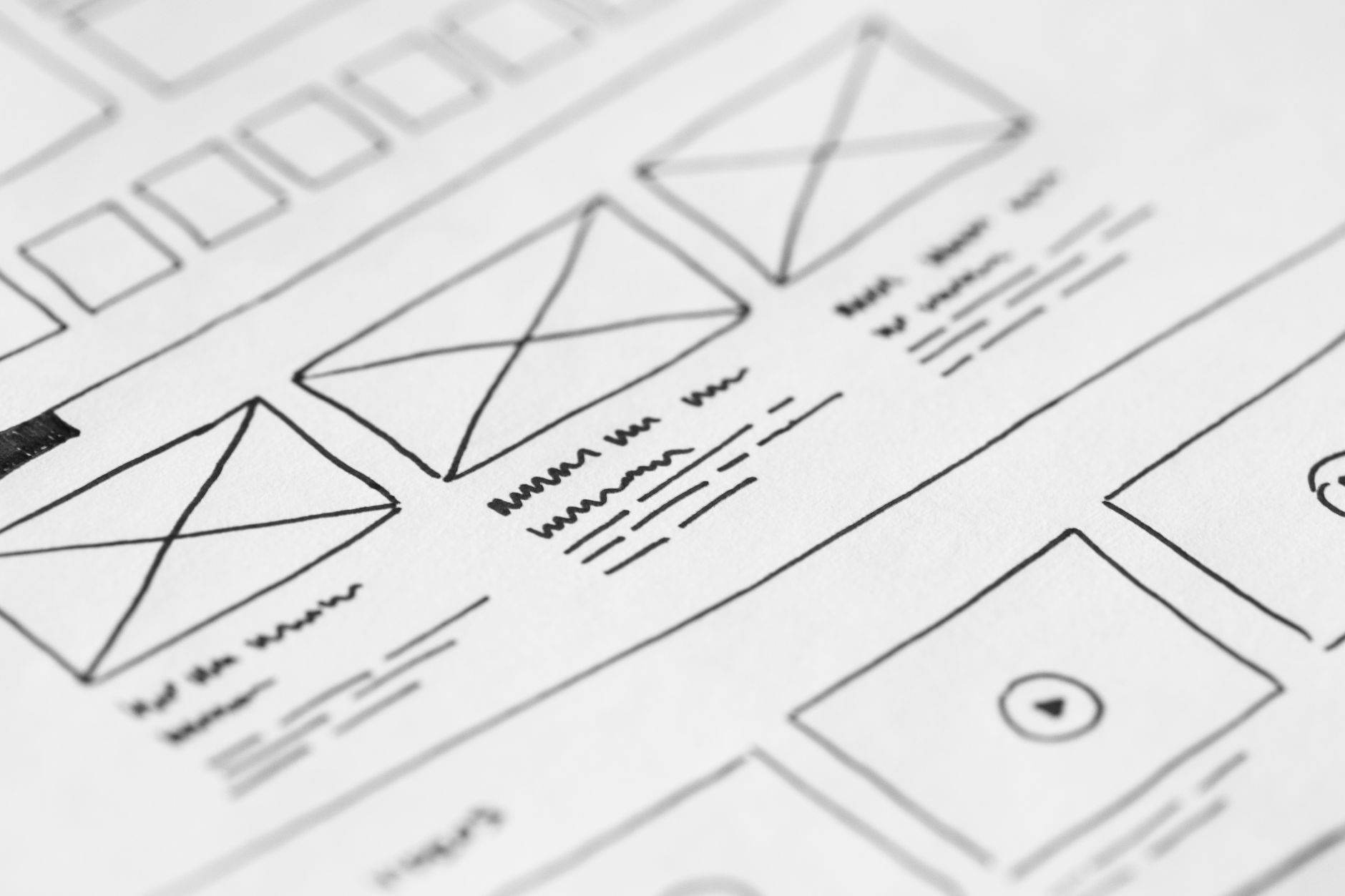 Hand-drawn wireframe sketch for a custom website layout on white paper