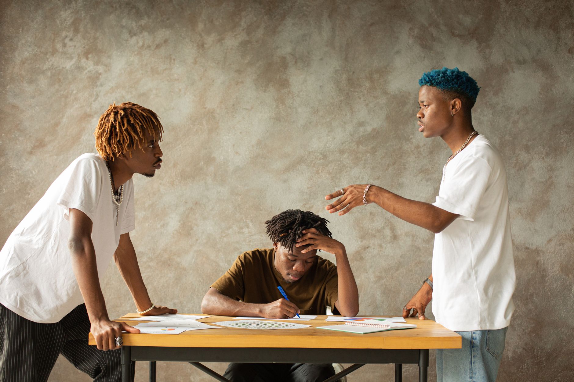 Two men arguing over papers while a third man mediates between them