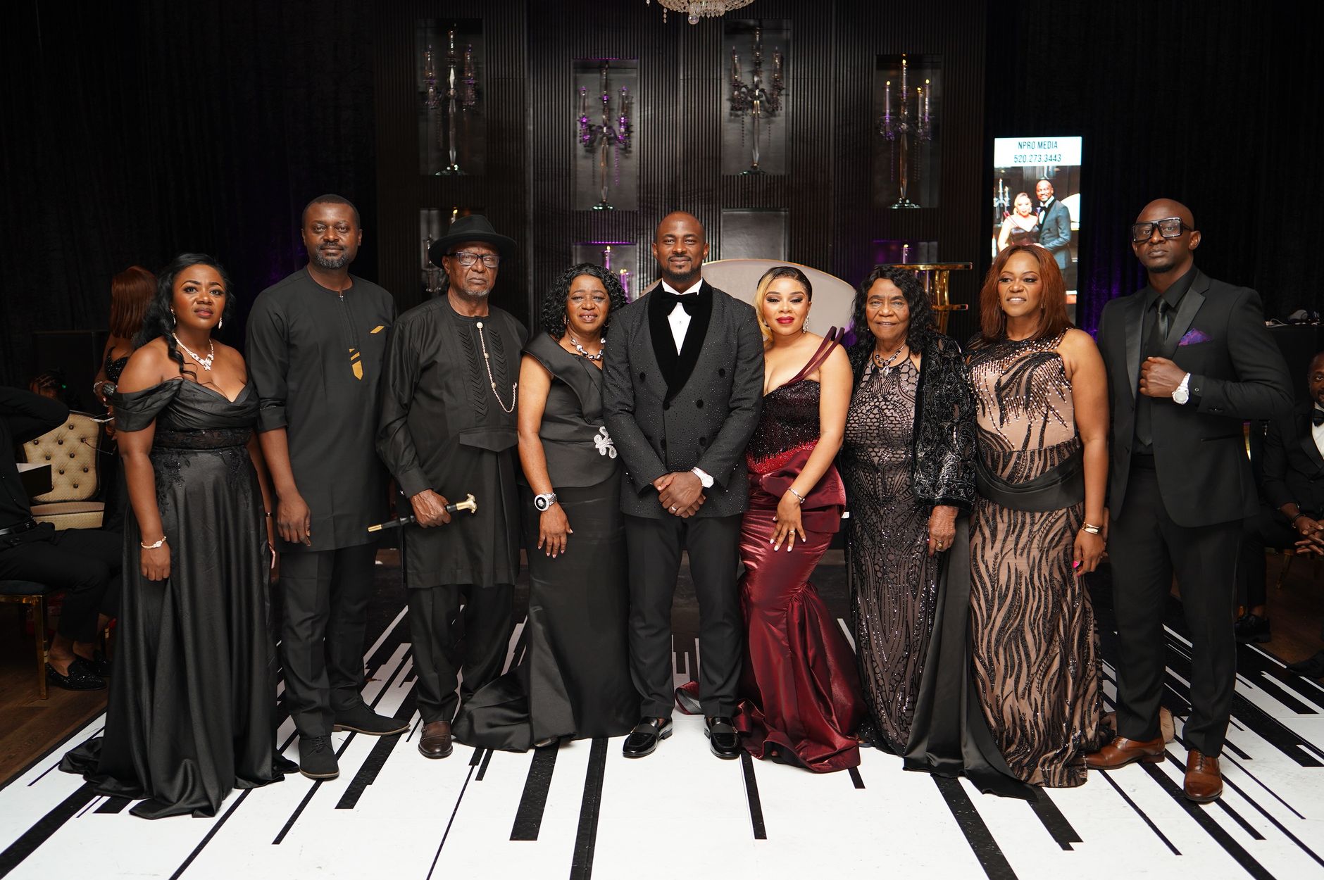 A group of elegantly dressed adults poses at a formal themed gala event