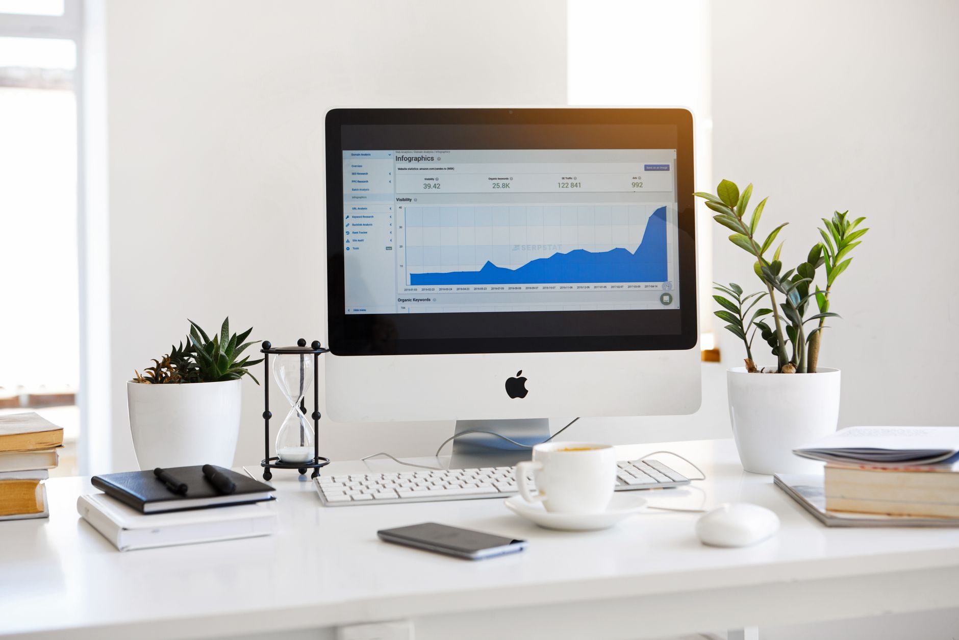 Computer monitor displaying website search analytics and performance charts on an office desk