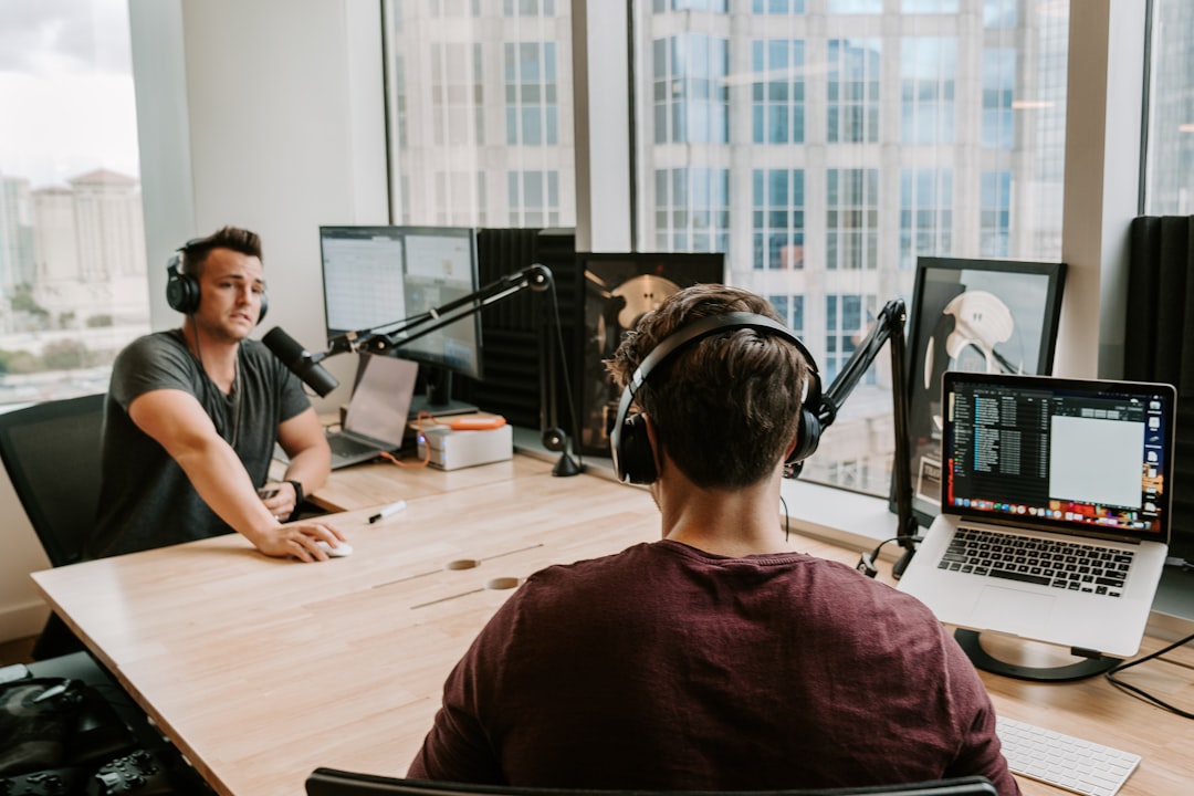 Two men in headphones record a podcast in a modern studio setting