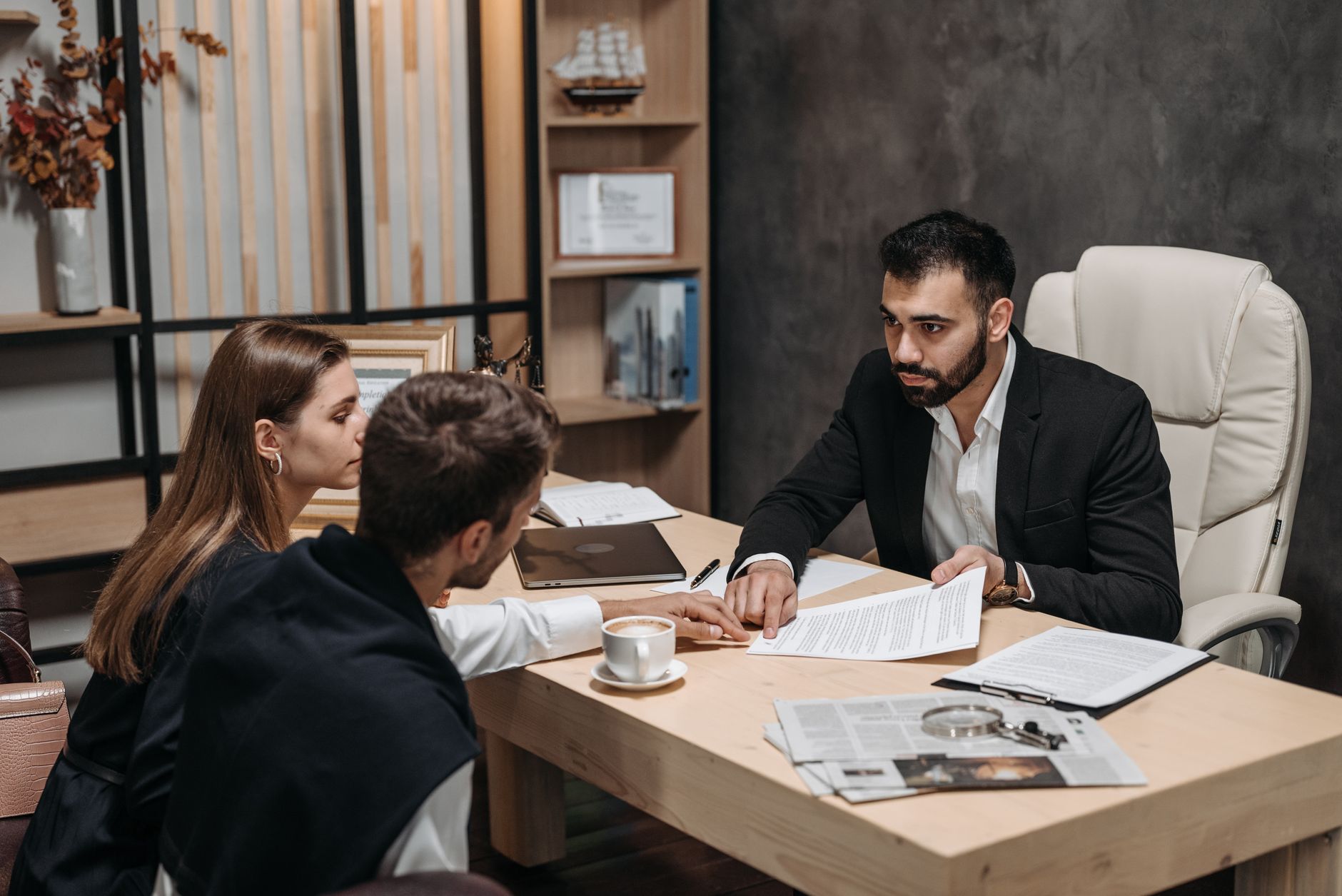Lawyer discussing intellectual property documents with two clients at an office table