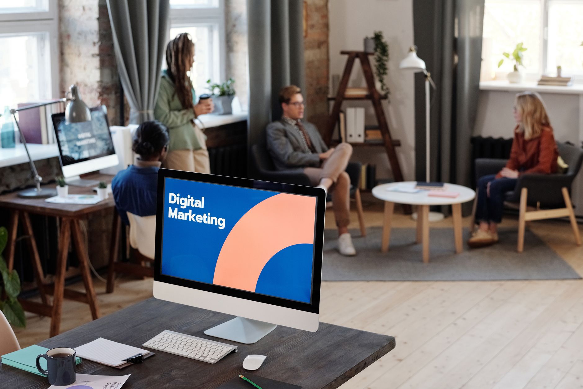 A computer monitor displaying digital marketing sits on a desk in an office