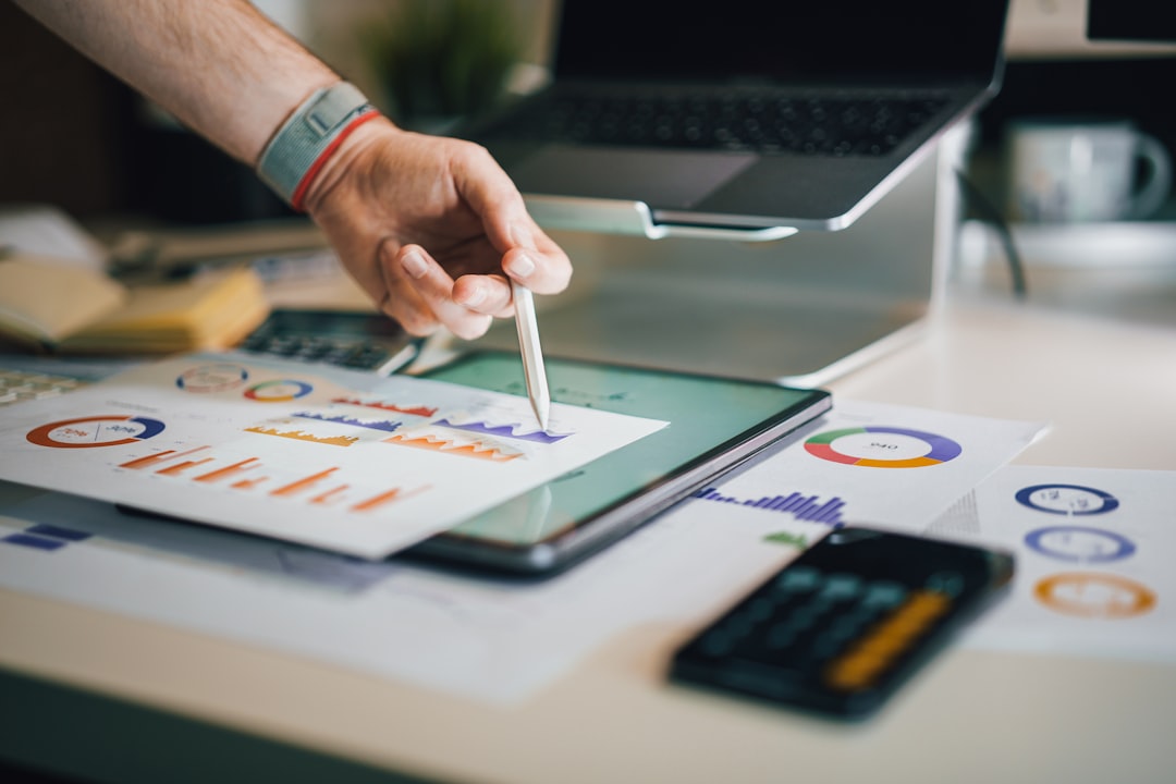 Hand pointing a stylus at marketing data charts, analyzing SEO service costs