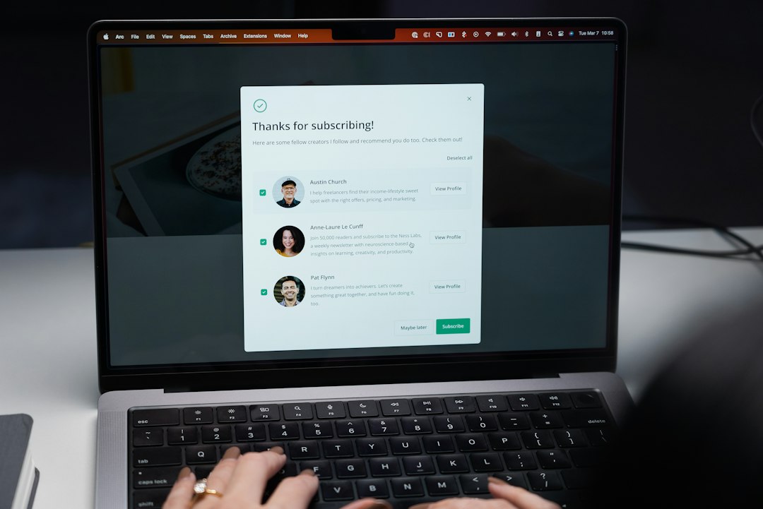 A person types on a laptop displaying a subscription confirmation popup screen