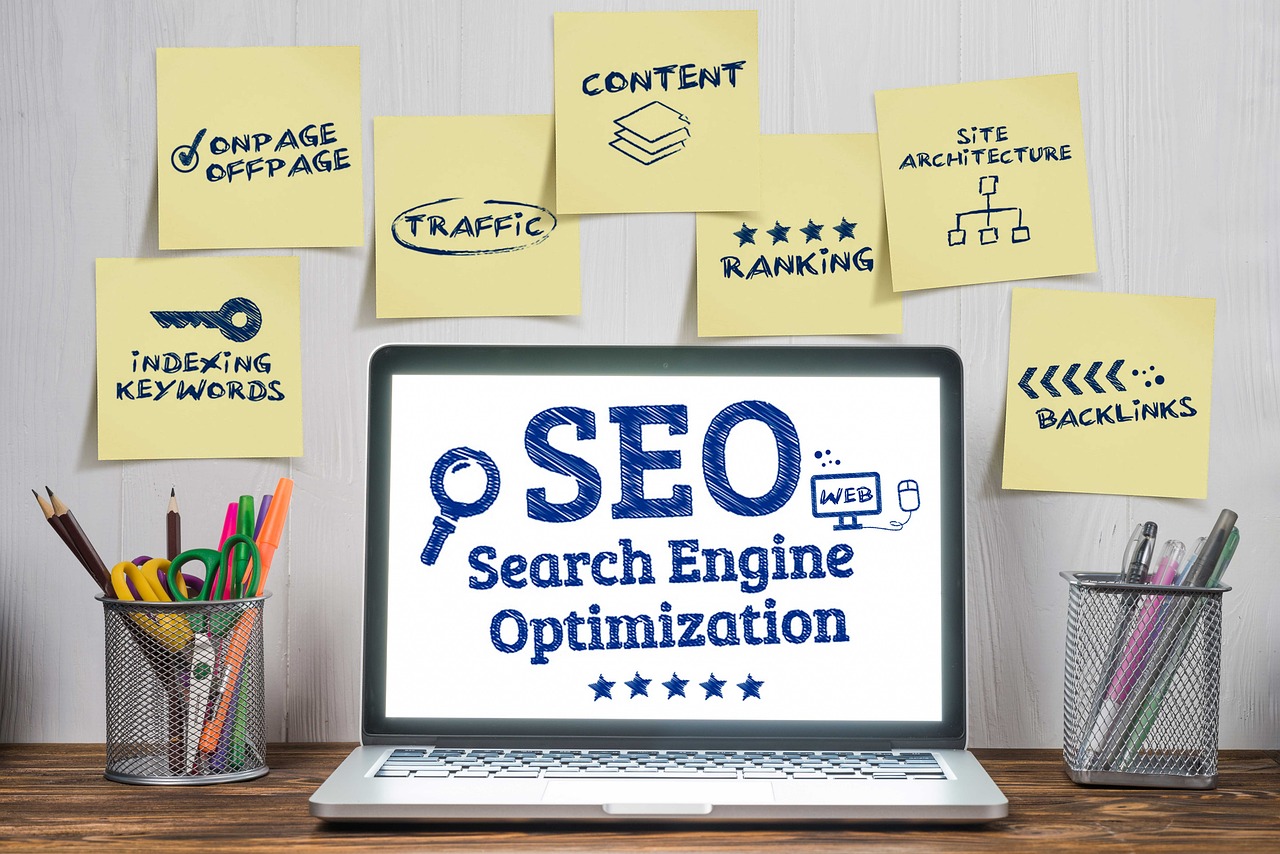 Laptop displaying "SEO" surrounded by sticky notes listing various SEO strategies