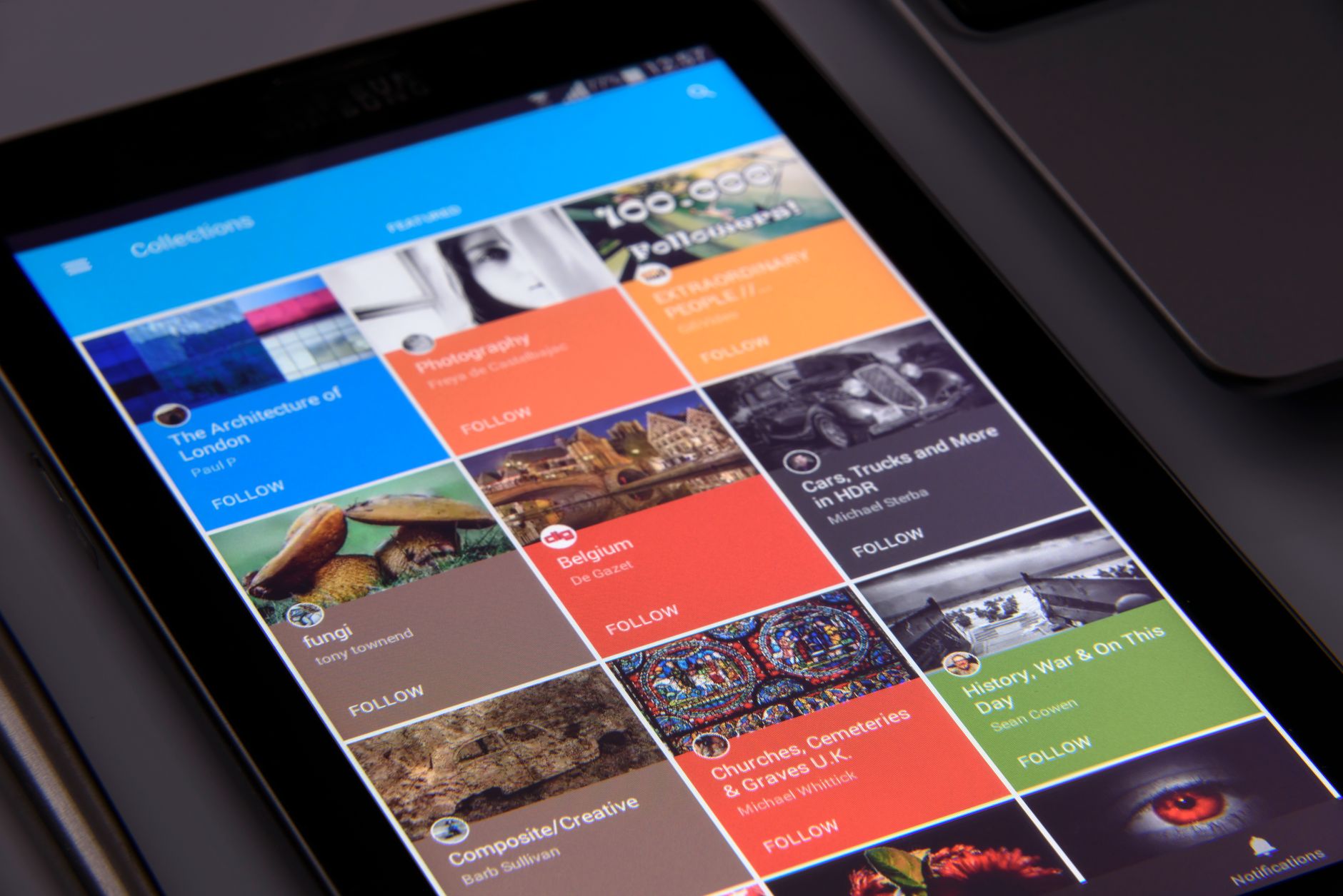 A tablet screen displays a grid of colorful image and text tiles