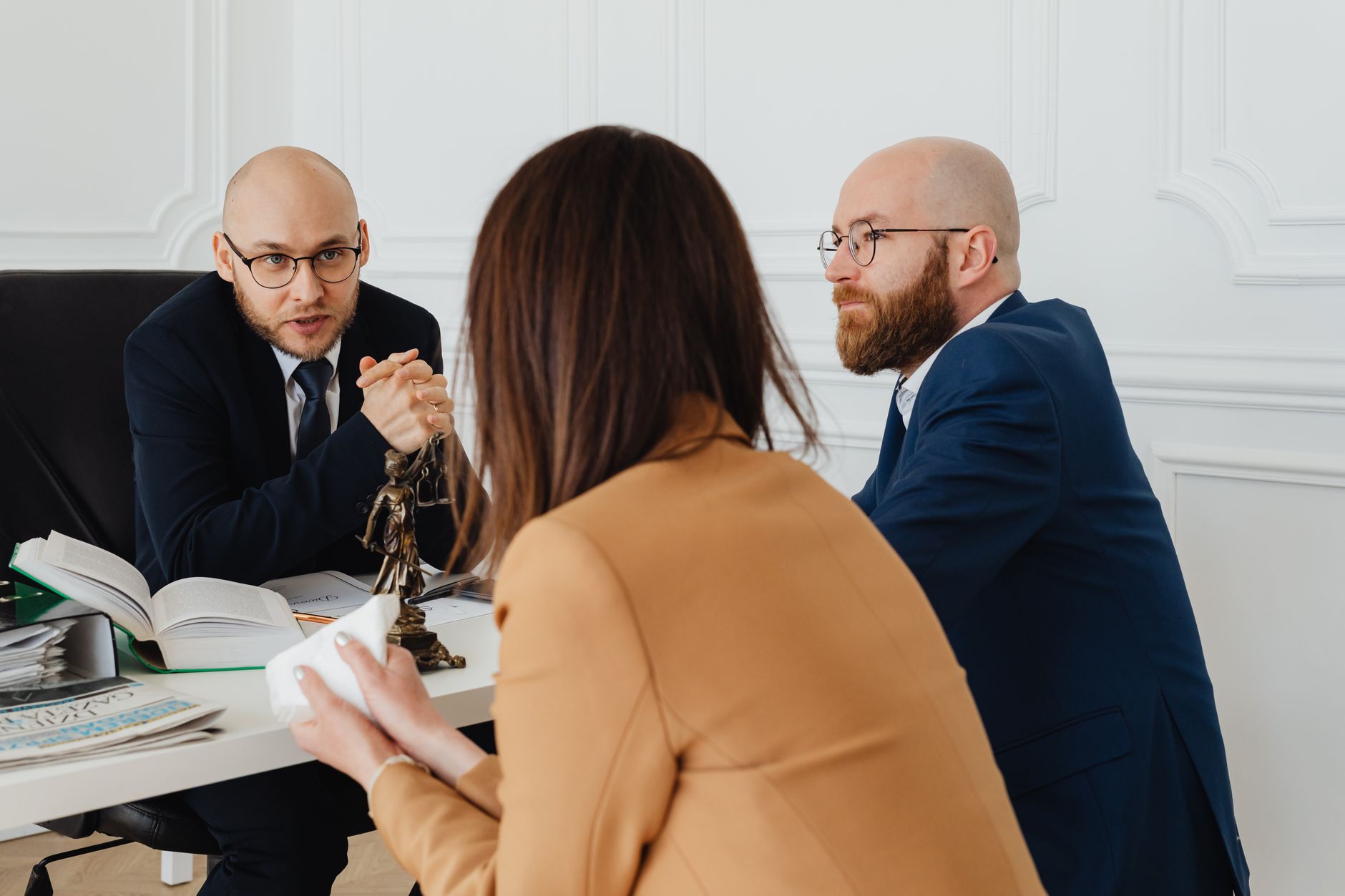 Two lawyers discuss commercial litigation with a client in an office